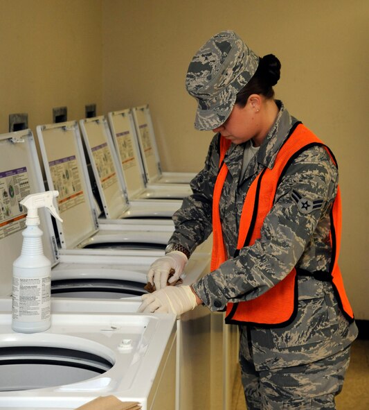 Airman 1st Class Alexis Randall, 2nd Contracting Squadron, cleans a washer during bay orderly duty on Barksdale Air Force Base, La., Jan. 31. Bay orderly duties include maintaining the cleanliness of the dorms. (U.S. Air Force photo/Airman 1st Class Andrew Moua)