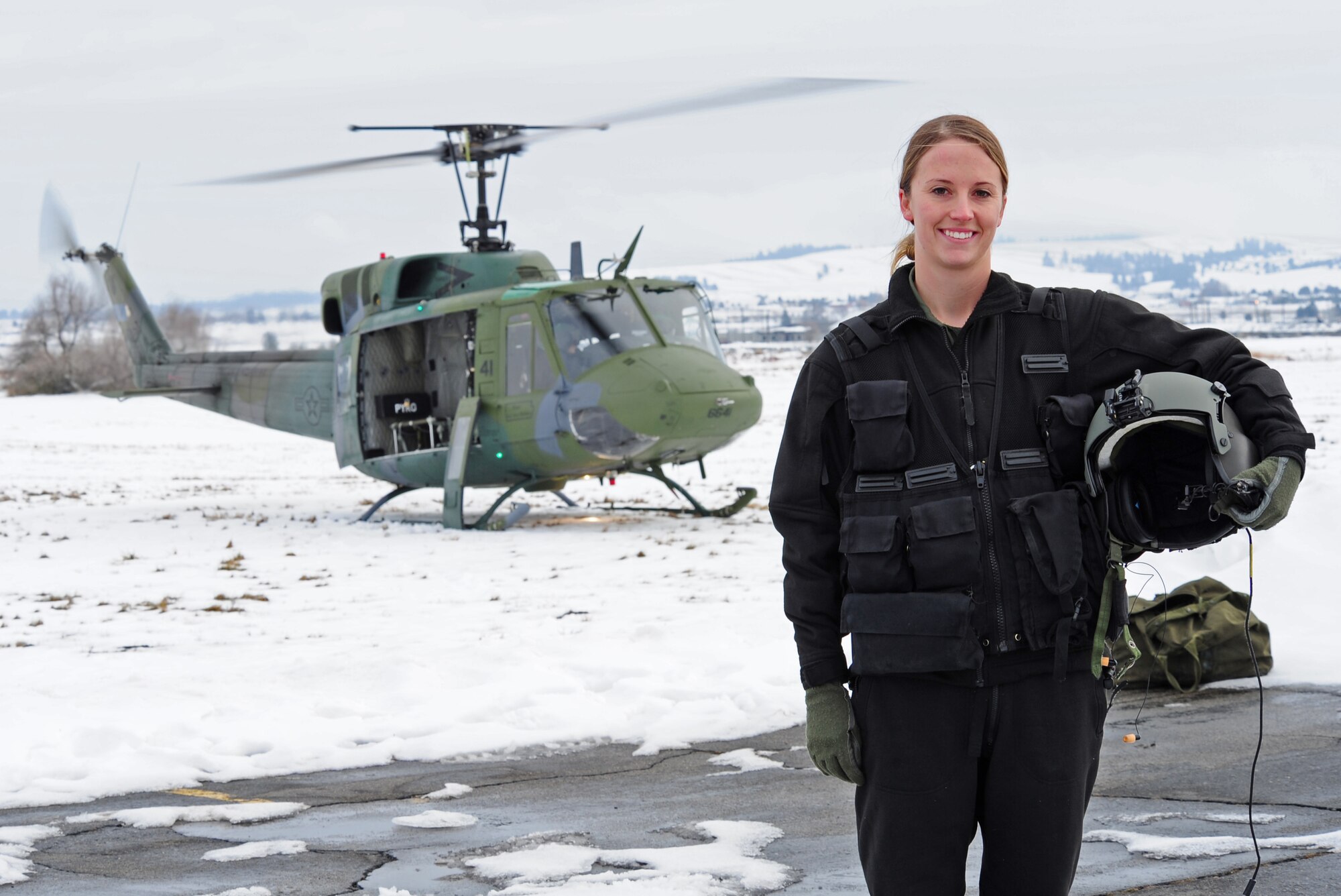 Capt. Ashly Barnes, the standardization and evaluation liaison officer, 36th Rescue Flight, poses next to a UH-1N helicopter at Fairchild Air Force Base, Wash. Jan. 25, 2012. Barnes was awarded the Air Education and Training Command Aviator Valor Award for the year 2012. (U.S. Air Force Photo by Airman 1st Class Janelle Patino)