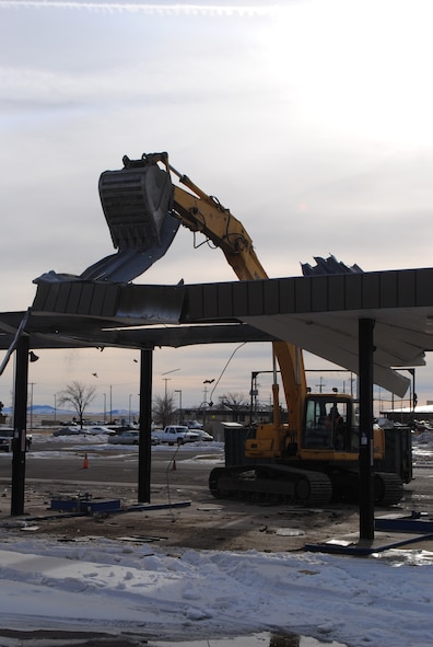 Using an excavator, contractors from EMR, Inc., out of Lawrence, Kan., tear down the canopy of Malmstrom’s old gas station.  Only the pump canopy was torn down during the demolition.  (U.S. Air Force photo/Senior Airman Cortney Paxton)