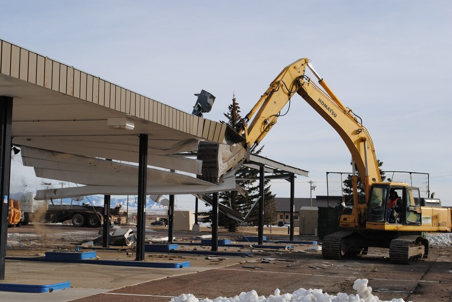 A member of EMR, Inc., out of Lawrence, Kan., operates an excavator to tear down Malmstrom’s old gas station pump canopy Jan. 23.  The demolition began Jan. 22 and continued through Jan. 25 when the tear-down was complete.  (U.S. Air Force photo/Senior Airman Cortney Paxton)