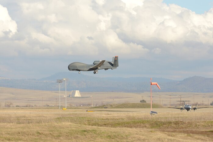 A U.S. Air Force RQ-4 Global Hawk unmanned aerial vehicle prepares to land as a MC-12 Liberty aircraft waits for takeoff at Beale Air Force Base, Calif., Jan. 25, 2013. (U.S. Air Force Photo by Mr. John Schwab/ Released)