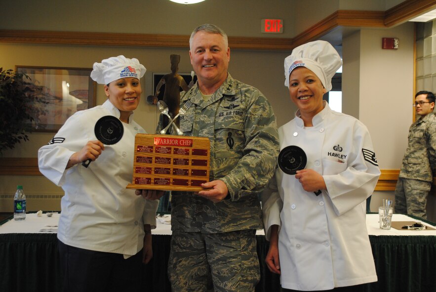 Winners of the first quarter Warrior Chef Competition, Senior Airman Miriam Santiago, 341st Force Support Squadron fitness apprentice, left, and Staff Sgt. Rowena Hawley, 341st FSS food service supervisor, pose with one of three judges, Maj. Gen. Michael Carey, 20th Air Force commander. Hawley and Santiago impressed judges with their island-flavored fajitas, island-style fried rice and pina coladas. (U.S. Air Force photo/Airman 1st Class Katrina Heikkinen)