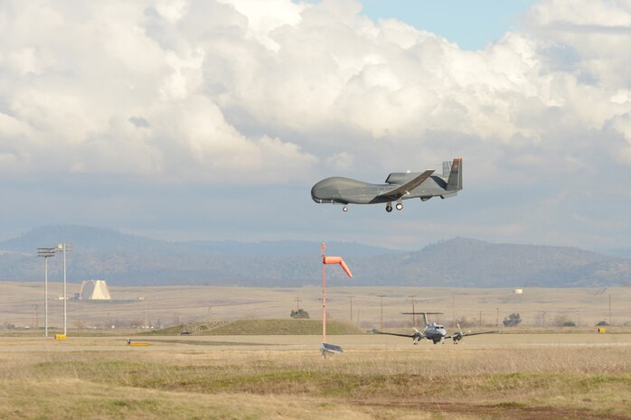 A U.S. Air Force RQ-4 Global Hawk unmanned aerial vehicle prepares to land as a MC-12 Liberty aircraft waits for takeoff at Beale Air Force Base, Calif., Jan. 25, 2013. (U.S. Air Force Photo by Mr. John Schwab/ Released)