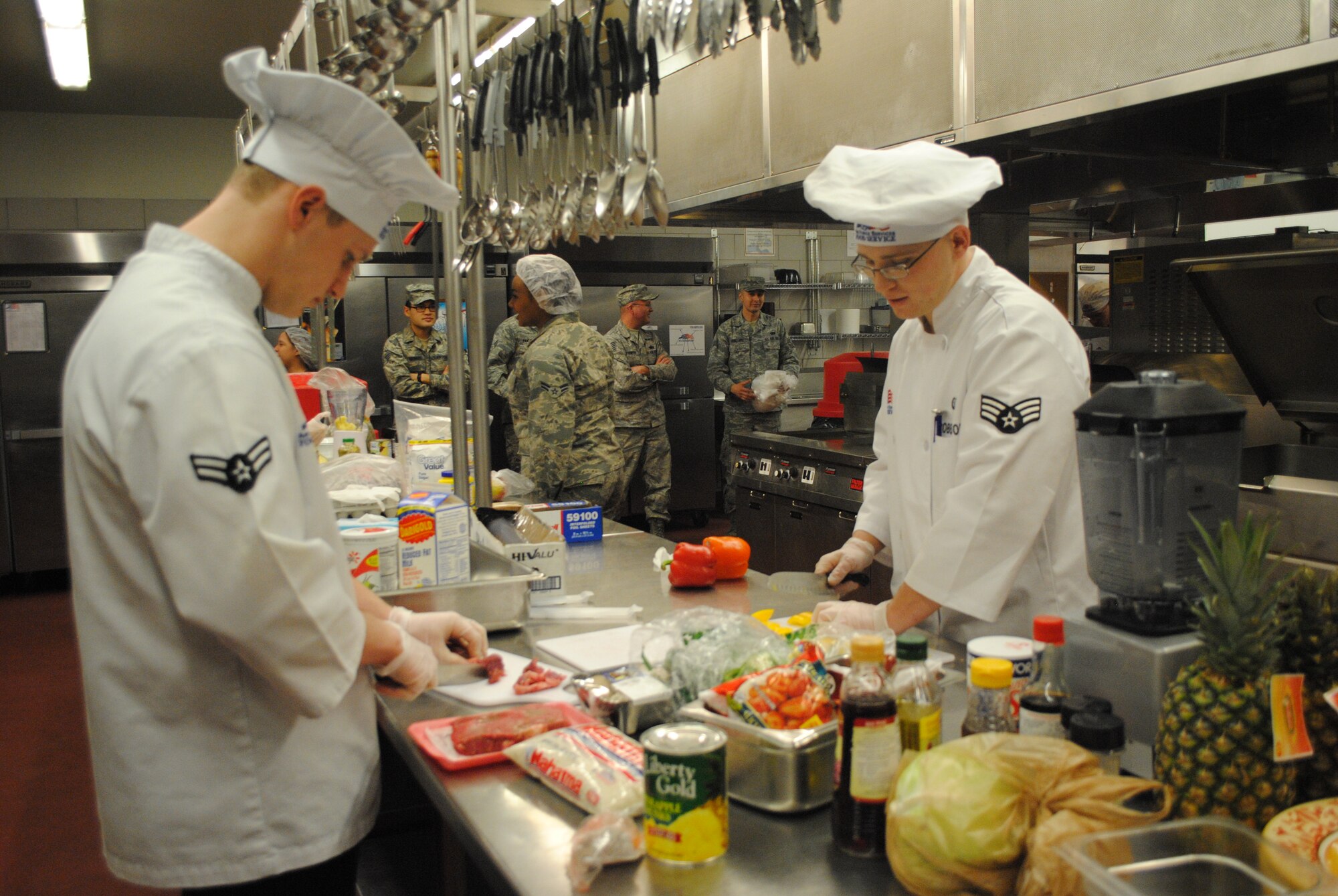 Airman 1st Class Bradlee Cullum, and his teammate Senior Airman Brady Robertson, 12th Missile Squadron chefs, prepare their entrée for the judges at the first quarter Warrior Chef Competition at the Elkhorn Dining Facility on Jan. 25. Robertson Cullum highlighted the theme ingredient – pineapple – in their dish consisting of pineapple kabobs, vegetable medley and pineapple smoothies. (U.S. Air Force photo/Airman 1st Class Katrina Heikkinen)