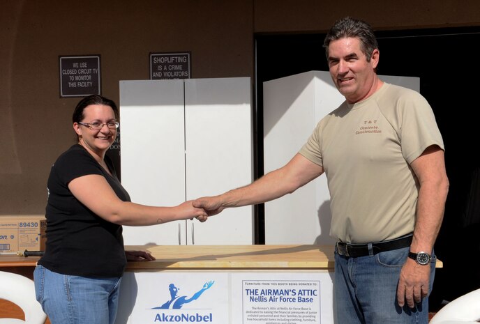 Mr. Jeff Taylor, an employee of Akzo Nobel Coatings, delivers donated furniture to Nicola Thompson, Airman's Attic volunteer, Jan. 25, 2013 at the Nellis Air Force Base Airman's Attic.  The Aiman's Attic is a non-profit organization run by volunteers supplying E-4's and below with no-cost household items. (U.S. Air Force photo by Tech Sgt. Taylor Worley)