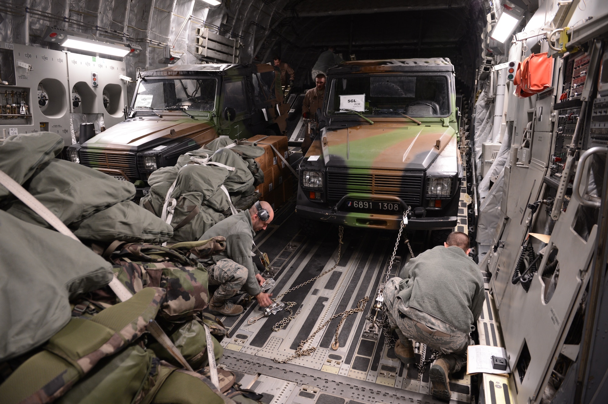 ISTRES, France -- U.S. Airmen from the 621st Contingency Response Wing, Joint Base McGuire-Dix-Lakehurst, N.J., and the 3rd Airlift Squadron, Dover Air Force Base, Del., secure a French military vehicle inside a U.S. Air Force C-17 Globemaster III. The C-17 can carry up to 170,900 pounds of cargo, and can be configured for a variety of loadouts, including aeromedical evacuation, cargo transportation and passenger movement. (U.S. Air Force photo by Staff Sgt. Nathanael Callon)
