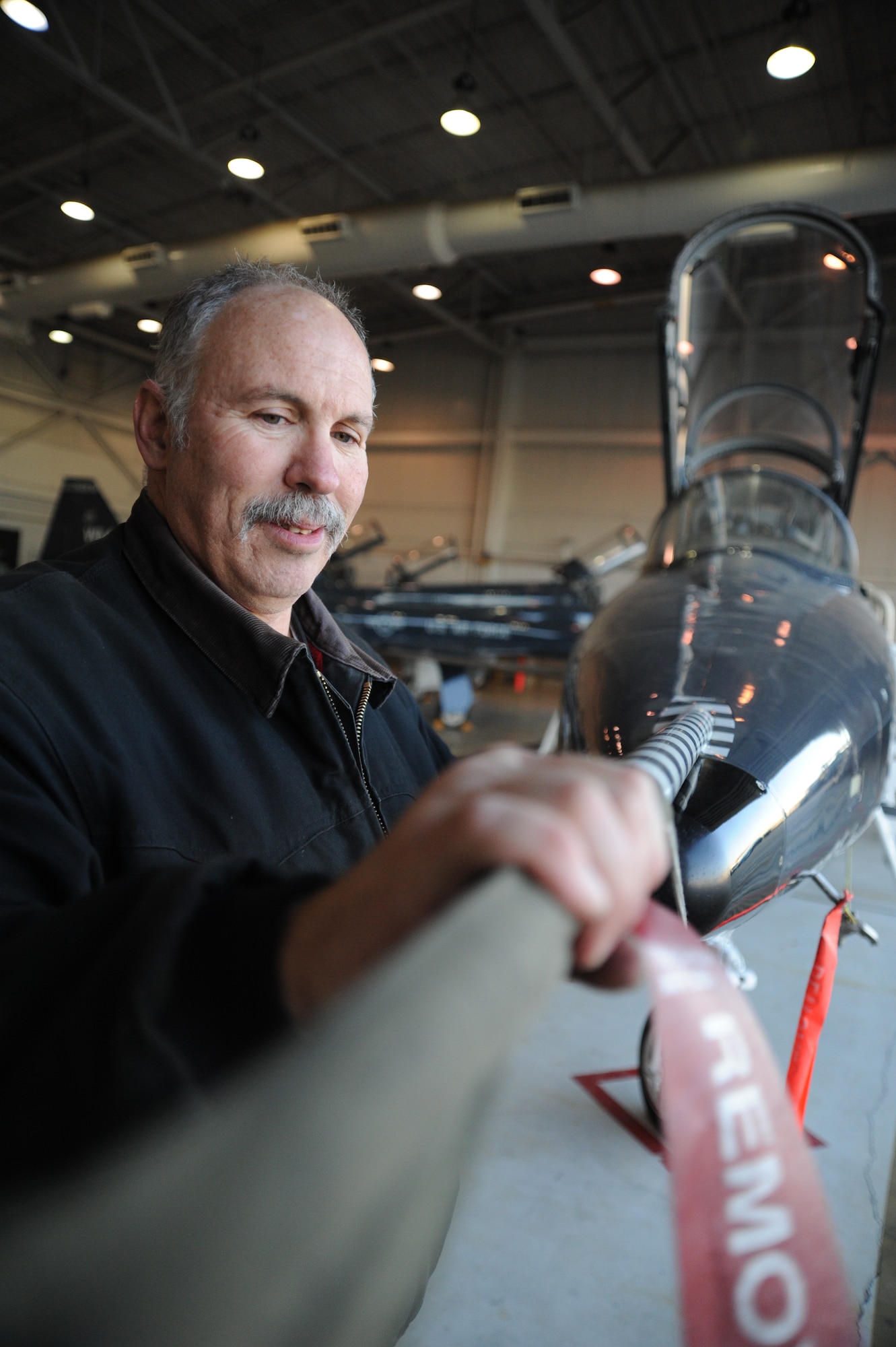 WHITEMAN AIR FORCE BASE, Mo. -- Russ Cass, M1 Support services aircraft mechanic, uses a pitot tube cover to cover an aircraft before “putting the aircraft to bed,” Jan 23. “Putting the aircraft to bed” is a term in maintenance that means the aircraft is being secured for the evening after the flying day. (U.S. Air Force photo/Staff Sgt. Nick Wilson) (Released)