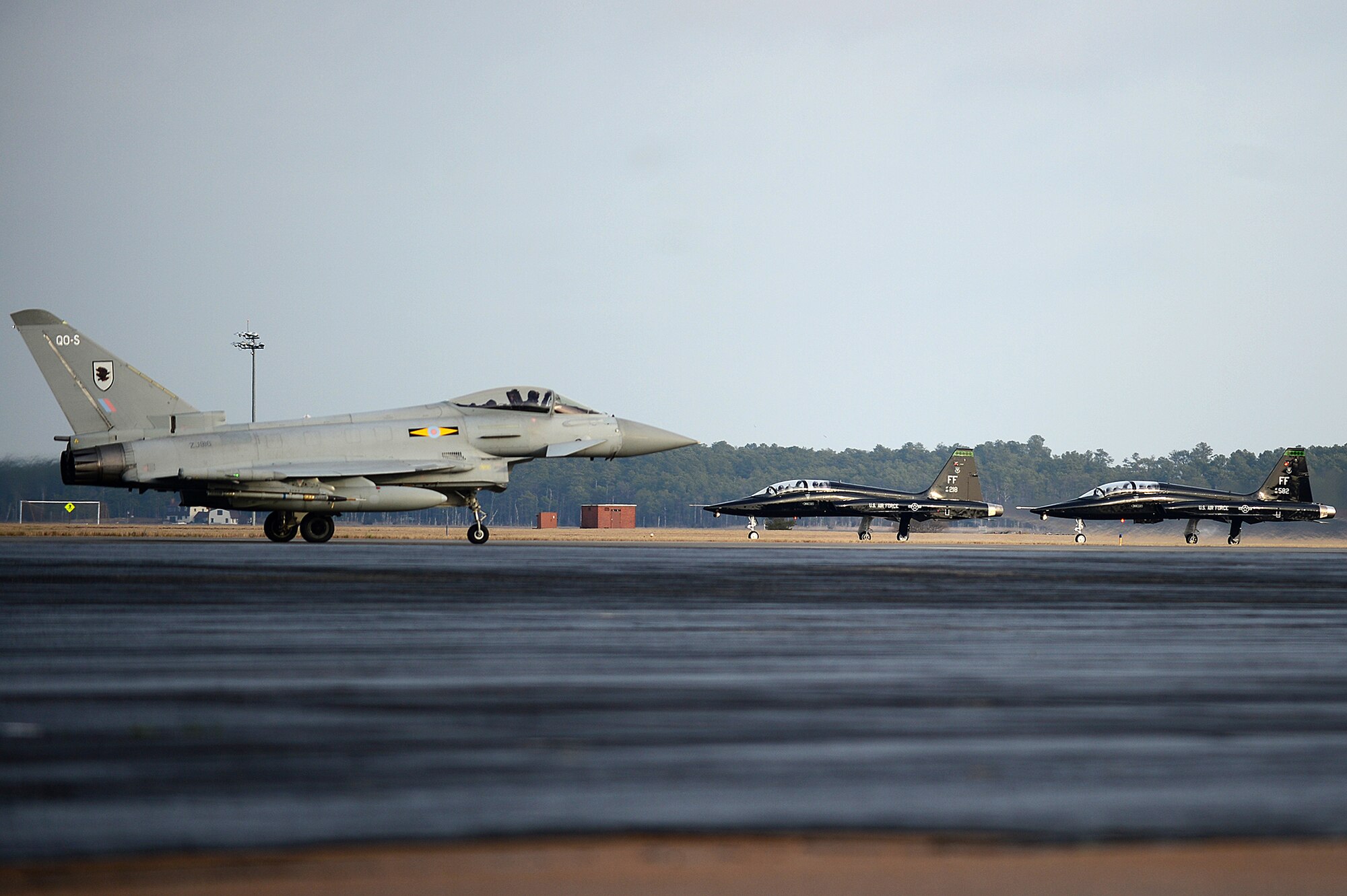 A Eurofighter Typhoon FGR4 taxis down the flightline as two T-38 Talons prepare to take off Jan. 30, 2013, at Joint Base Langley-Eustis, Va. The jets are participating in Exercise Western Zephyr, which tests the capabilities and tactics of the Typhoon.  (U.S. Air Force photo/Senior Airman Kayla Newman)