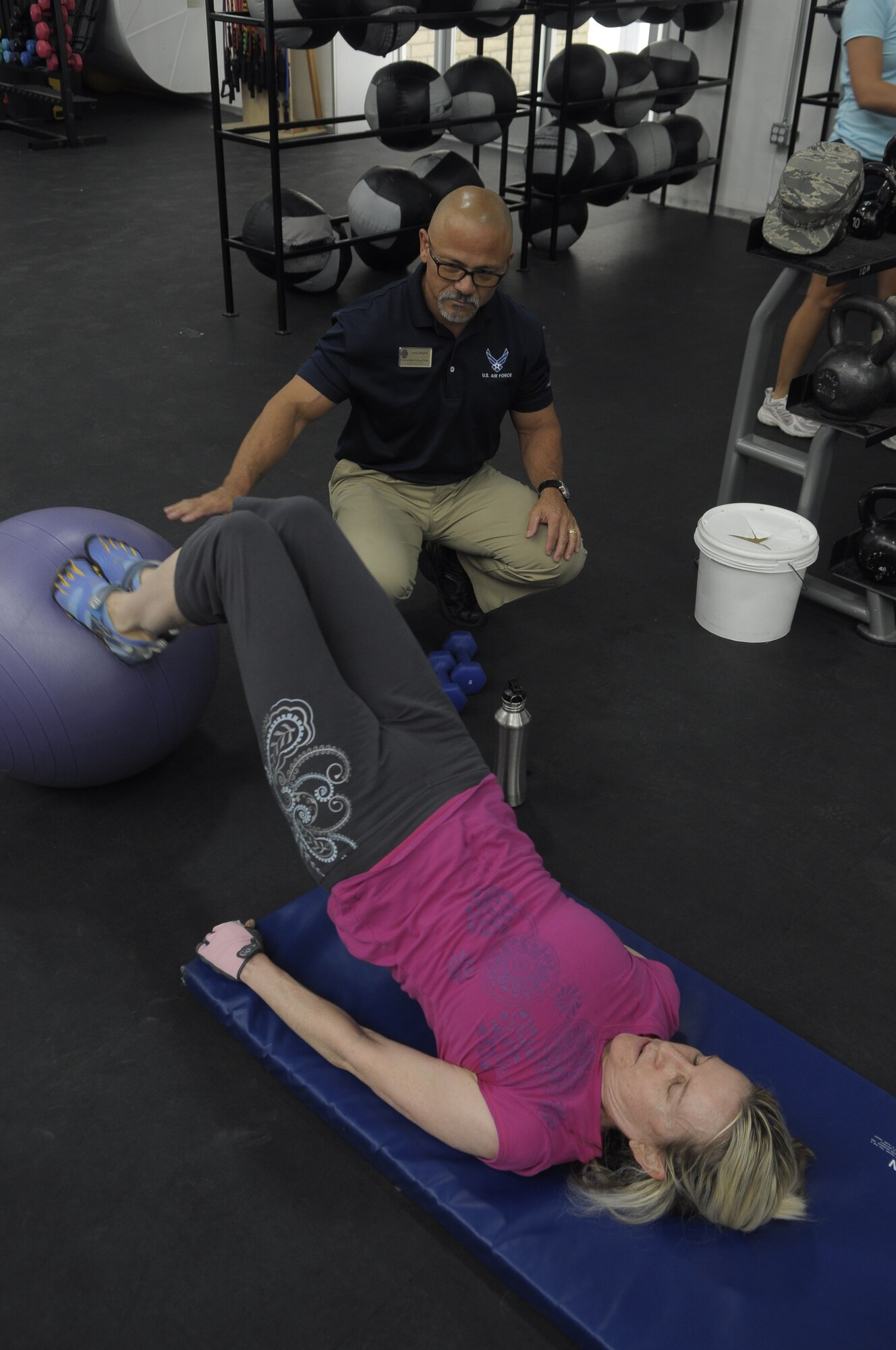Paul Johnson, 56th Force Support Squadron personal trainer, instructs Julie Kenkel on proper technique during a workout at the Luke Air Force Base Warrior Fitness Center. Johnson is one of two personal trainers available at the Bryant Fitness Center who train military members, dependents and retirees. For more information or to schedule an appointment with a trainer, call (623) 856-6421. (U.S. Air Force photo/Senior Airman Kate Vaughn)
