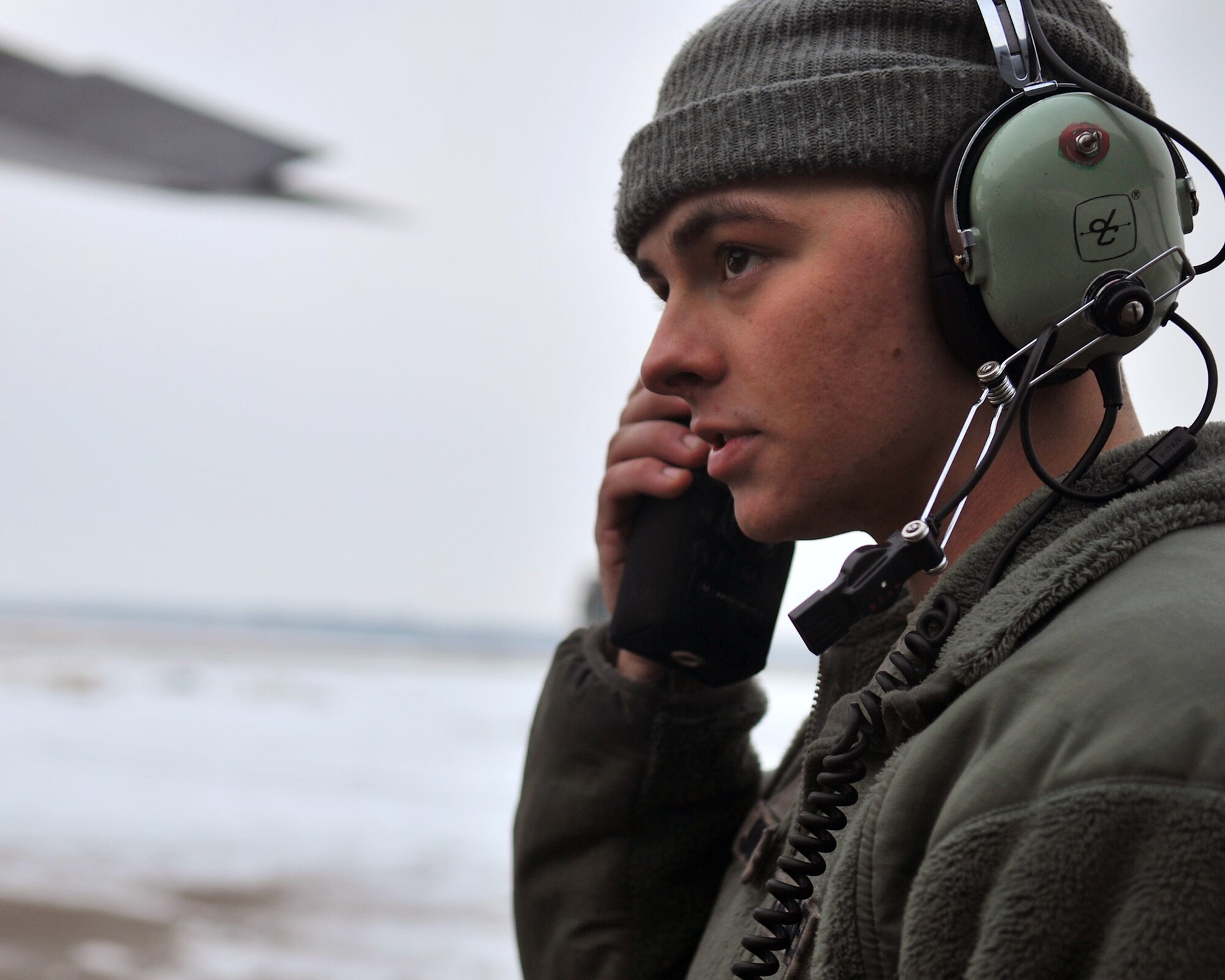 Senior Airman Maverick Jones, 100th Aircraft Maintenance Squadron crew chief relays a message via radio to maintenance personnel standing by on the flightline Jan. 23, 2013, at RAF Mildenhall, England. (U.S. Air Force photo by Senior Airman Jerilyn Quintanilla/Released)
