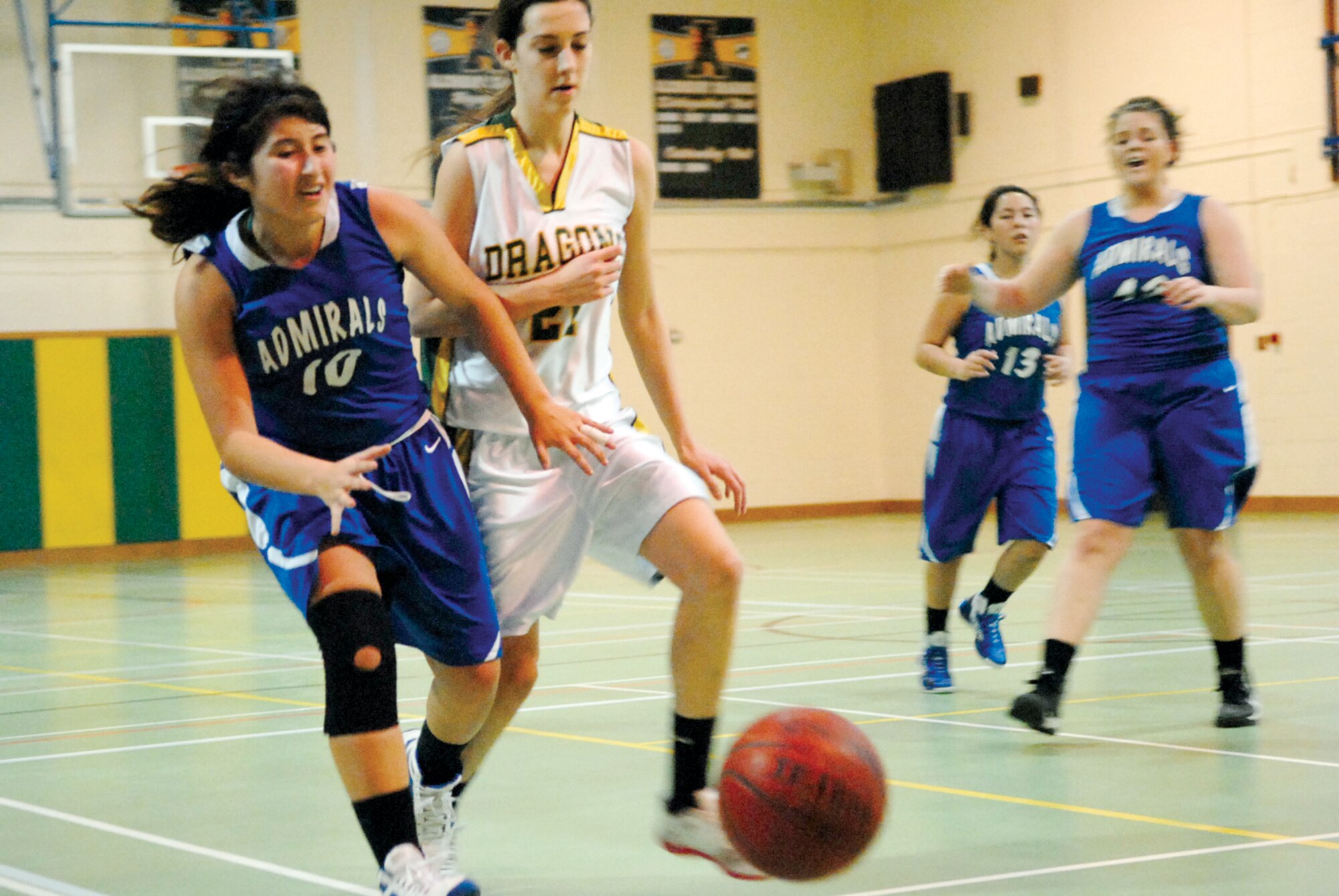 RAF ALCONBURY, United Kingdom – Rota senior Keanna Garcia, left, and Alconbury junior Taylor Currie chase after the ball during action Saturday at the DODDS-Europe Division III winter basketball tournament at RAF Alconbury, United Kingdom. Alconbury won the game, 30-21. (Photo by Jennifer H. Svan/Stars and Stripes)