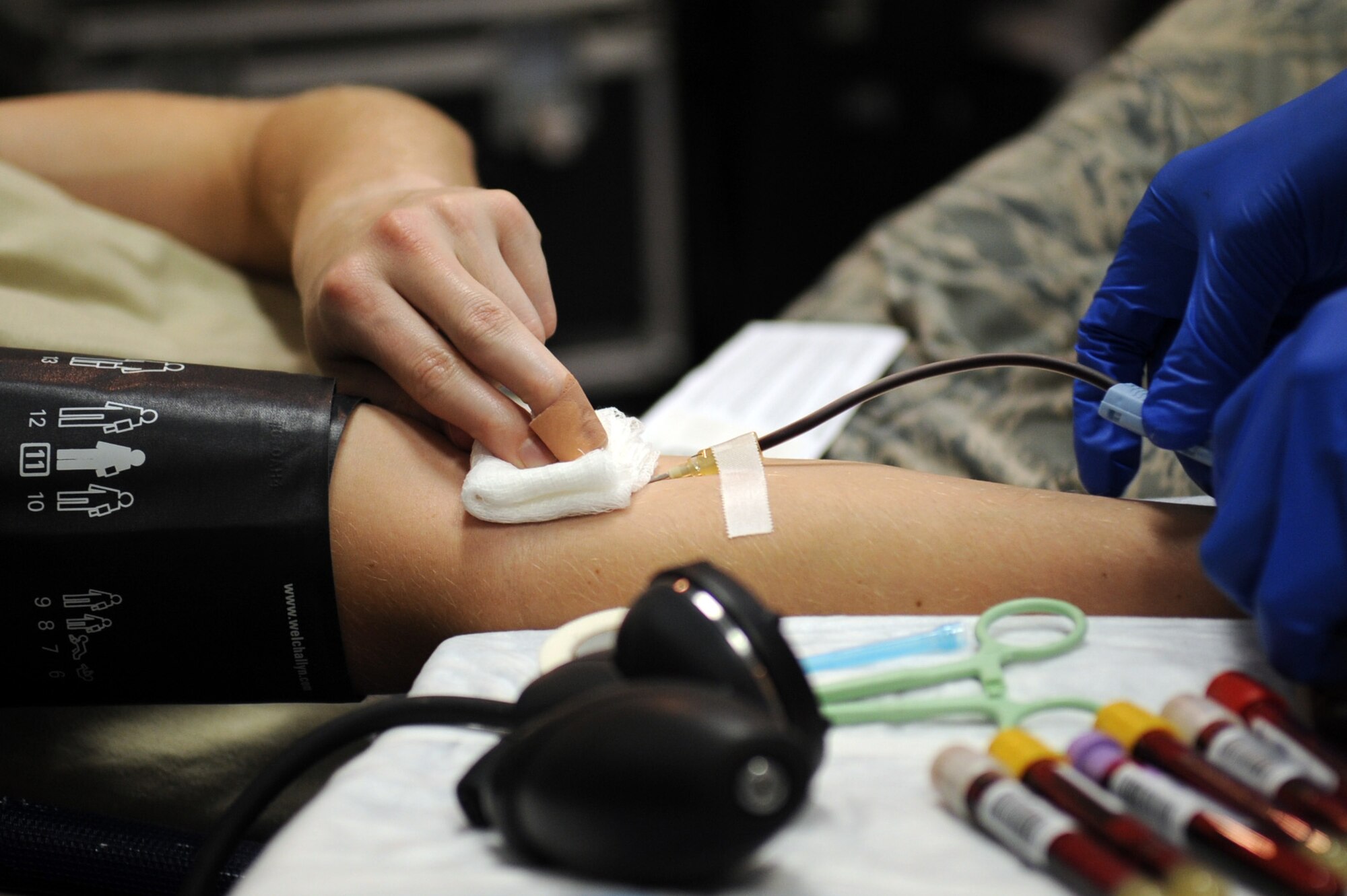 U.S Air Force Airman 1st Class Robert Black, 18th Communication Squadron information protection technician, applies pressure to his arm after donating blood on Kadena Air Base, Japan, Jan. 29, 2013. The blood drive was to kick off Blood Donor Month for the Armed Services Blood Program. (U.S. Air Force photo/Naoto Anazawa)