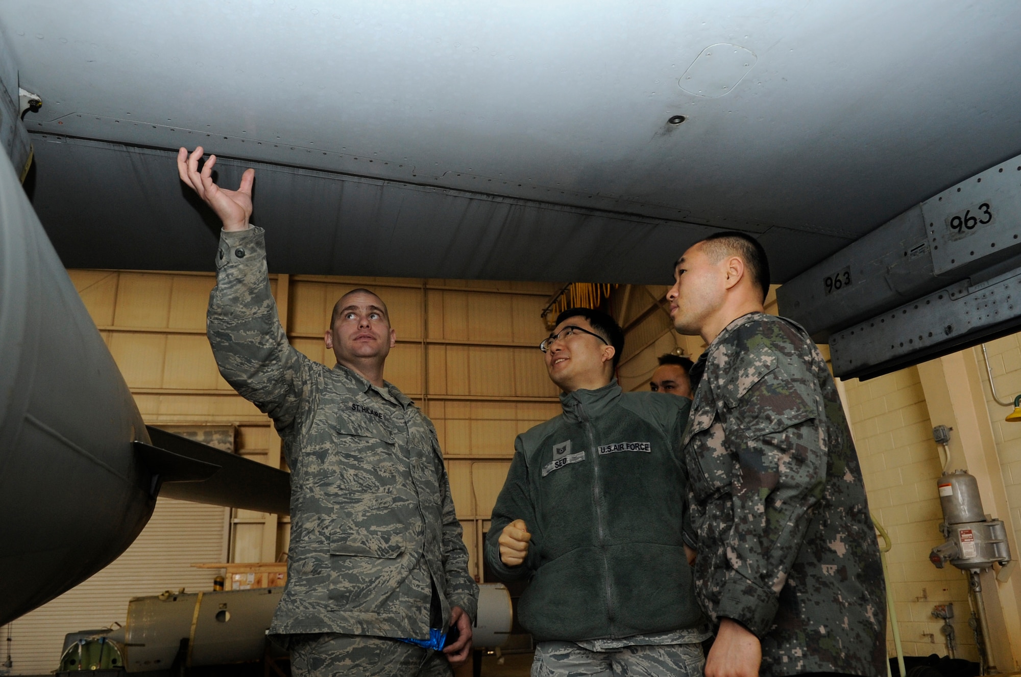 Tech. Sgt. Rene St. Hilaire, left, 8th Maintenance Squadron aircraft fuels system craftsman, talks to Republic of Korea Air Force Master Sgt. Jin Gook Lee with the help of translator Tech. Sgt. Felix Seo, 8th Comptroller Squadron, Jan. 30, 2012, at Kunsan Air Base, Republic of Korea. During this career exchange day, four U.S. Airmen from maintenance career fields spent the day with their ROKAF counterparts to learn the details about daily operations. (U.S. Air Force photo by Senior Airman Brigitte N. Brantley/Released)