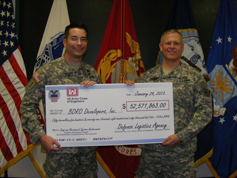 Lt. Col. Edward Chamberlayne (left), U.S. Army Corps of Engineers, Charleston District, teams up with Baltimore District Commander Col. Trey Jordan to present the ceremonial check for the project to replace the 1.6 million square foot roof and mechanical systems at the Eastern Distribution Center, DLA Distribution, New Cumberland, Pa. This Sustainment, Restoration and Modernization project will be completed in 2015.