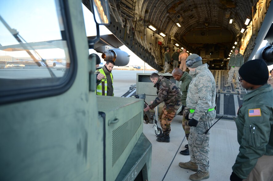 ISTRES, France - U.S. Airmen and French soldiers load equipment onto a U.S. Air Force C-17 Globemaster III in Istres, France, Jan. 21, 2013.  The United States has agreed to help France airlift troops and equipment into Mali. (U.S. Air Force photo by Staff Sgt. Nathanael Callon) (Released)