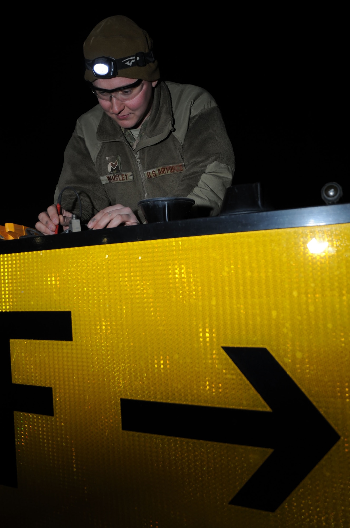 Senior Airman Luke Wamsley, 455th Expeditionary Civil Engineer Squadron electrical systems journeyman, maintains a runway sign on Bagram Airfield, Afghanistan, Jan. 31, 2013. The Airfield Lighting team is responsible for maintaining the various lighting systems on the Bagram flightline. (U.S. Air Force photo/Staff Sgt. David Dobrydney)