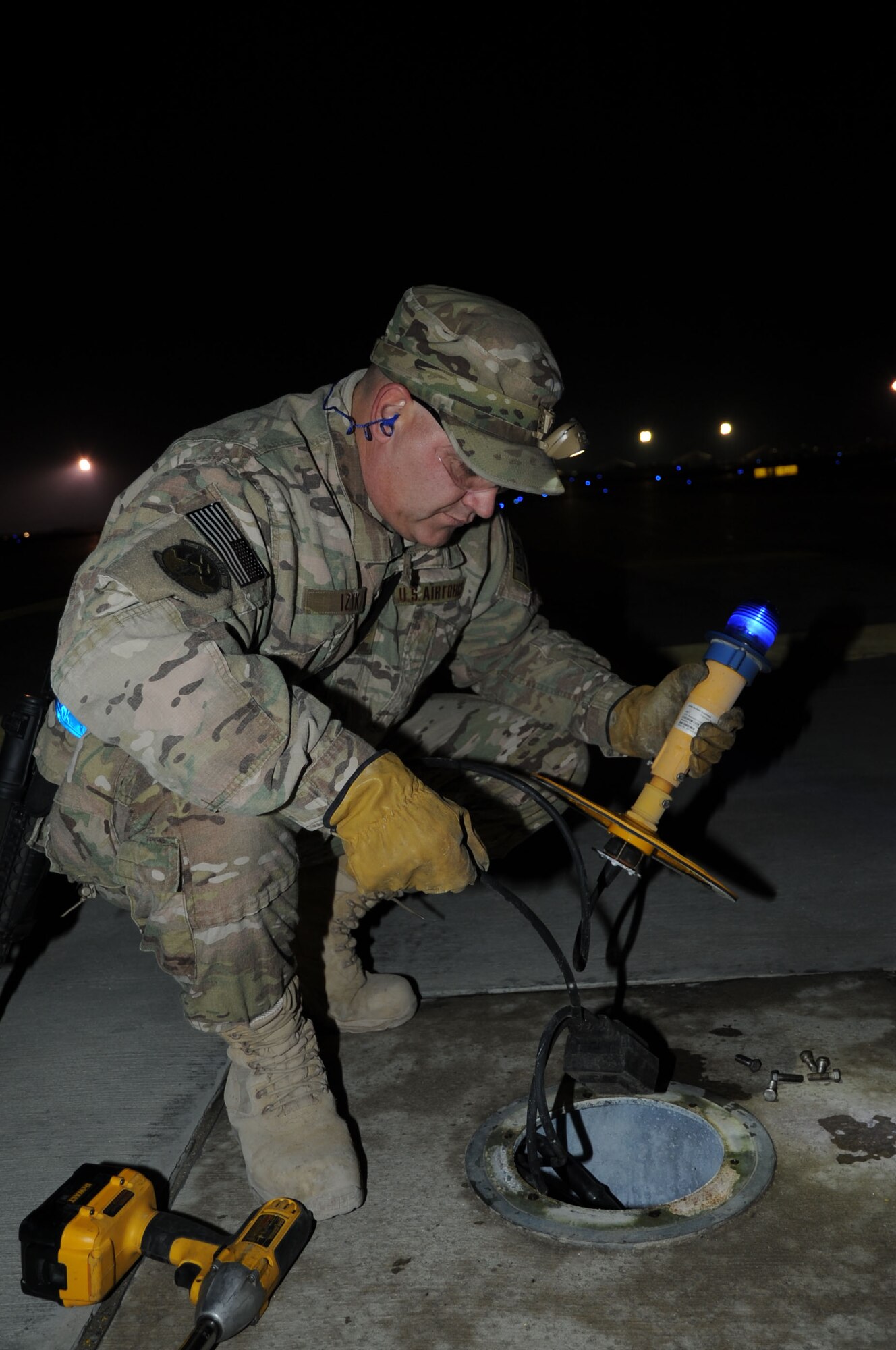 Staff Sgt. Paul Izyk, 455th Expeditionary Civil Engineer Squadron electrical systems journeyman, removes a taxiway light for inspection on Bagram Airfield, Afghanistan, Jan. 31, 2013. Izyk is a member of the Airfield Lighting team which goes out nightly to inspect and maintain lighting systems around the flightline. (U.S. Air Force photo/Staff Sgt. David Dobrydney)