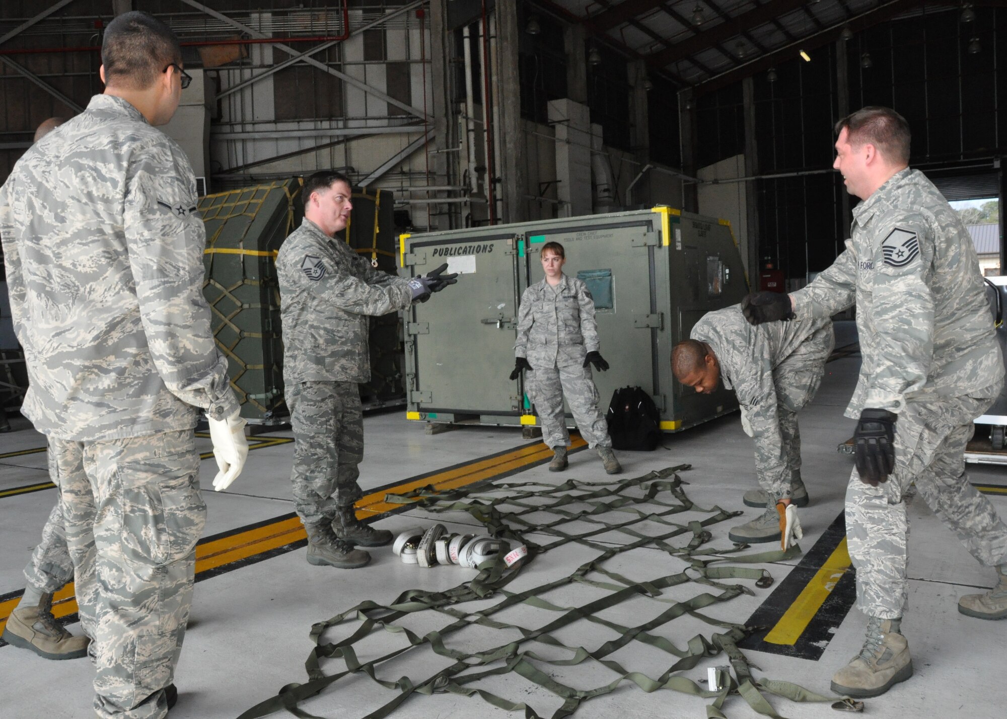 Master Sgt. Scott M. Miller, 71st Aerial Port Squadron, shows members of the 916th Air Refueling Wing the proper steps when using cargo netting to secure palletized equipment. (USAF photo by MSgt. Wendy Lopedote, 916ARW/PA)
