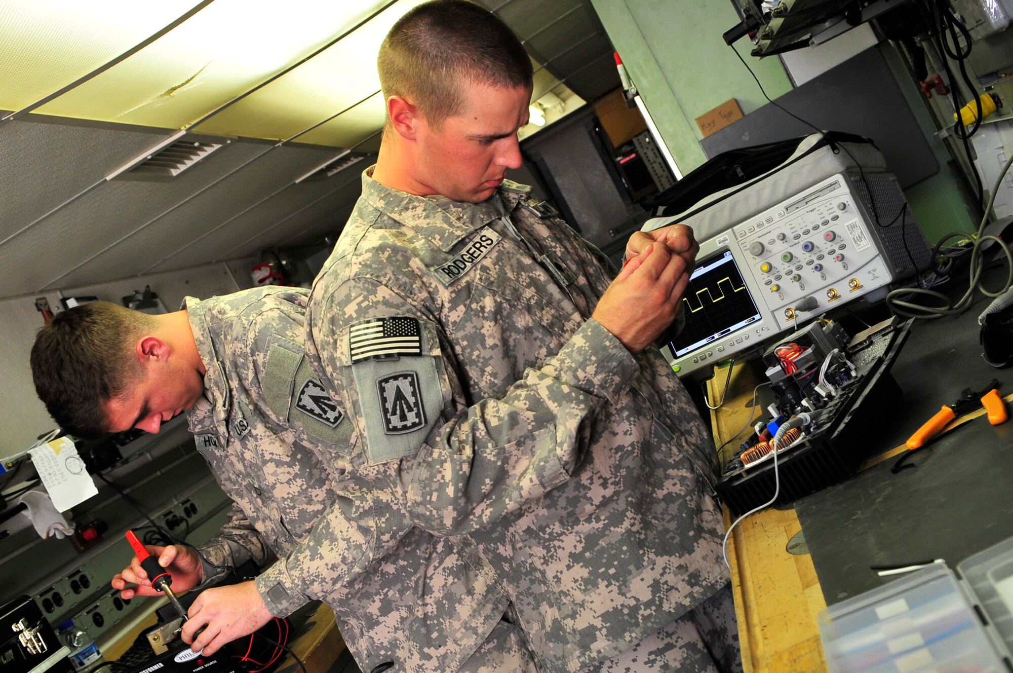 SOUTHWEST ASIA -- U.S. Army Pfc. John Howard and Spc. Christopher Rodgers, Headquarters and Headquarters Battery, 1st Battalion 7th Air Defense Artillery PATRIOT system repairers, fix a voltage converter Jan. 31, 2013. Soldiers assigned to the 1-7 ADA established the Army Repair Shop, working hand-in-hand with the Air Force’s self-help shop to coordinate the repair of various types of electronic equipment broken by service members. (U.S. Air Force photo/Tech. Sgt. Christina M. Styer)(RELEASED)