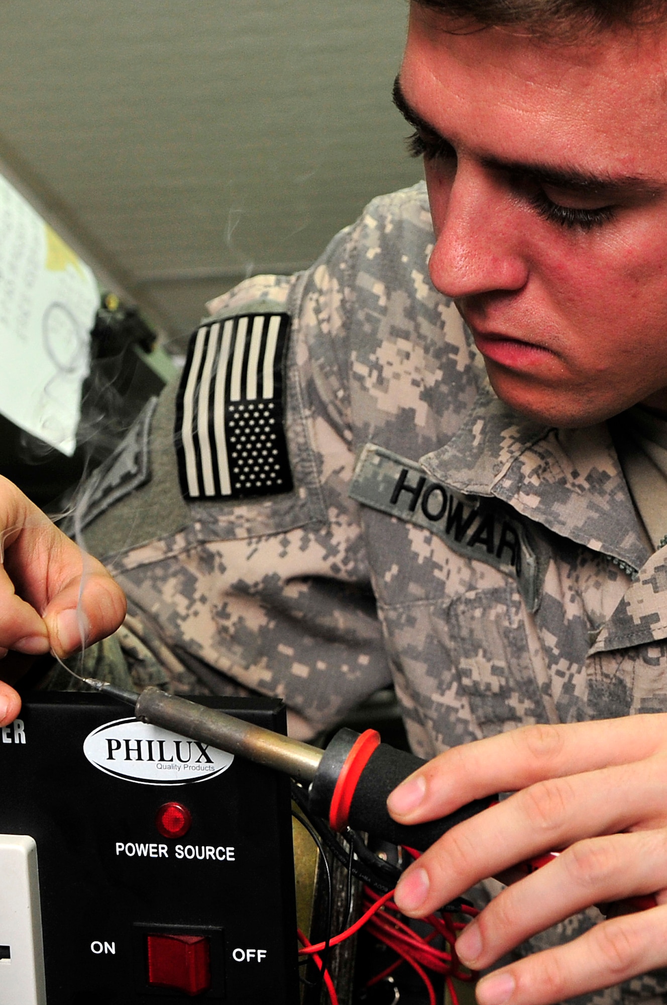 SOUTHWEST ASIA -- U.S. Army Pfc. John Howard, Headquarters and Headquarters Battery, 1st Battalion 7th Air Defense Artillery PATRIOT system repairer, fixes a public address system Jan. 31, 2013. The Soldiers who run the Army Volunteer Repair Shop, deployed here to maintain and repair the PATRIOT missile system, have saved personnel just under $70,000 in the replacement of game systems, controllers, televisions, cell phones, power converters, and single-portion coffee makers. (U.S. Air Force photo/Tech. Sgt. Christina M. Styer)(RELEASED)