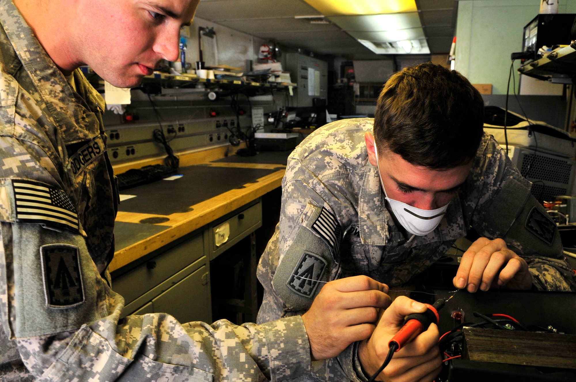 SOUTHWEST ASIA -- U.S. Army Spc. Christopher Rodgers and Pfc. John Howard, Headquarters and Headquarters Battery, 1st Battalion 7th Air Defense Artillery PATRIOT system repairers, fix a voltage converter Jan. 31, 2013. Soldiers assigned to the 1-7 ADA maintain the PATRIOT missile system and remain proficient at their craft by repairing items broken by other service members. (U.S. Air Force photo/Tech. Sgt. Christina M. Styer)(RELEASED)