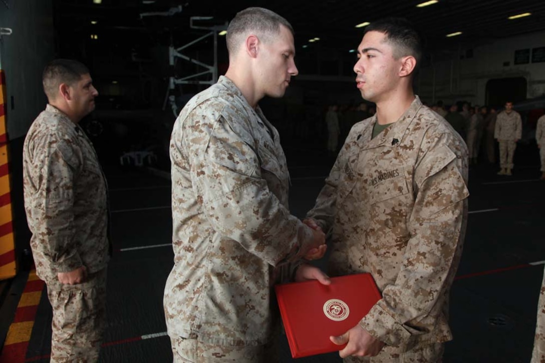 Newly promoted Sgt. Jonathan A. Renderos, embarkation chief, Headquarters and Service Company, Battalion Landing Team 3/5, 15th Marine Expeditionary Unit, receives his promotion warrant from Capt. Braxton H. Mashburn, his commanding officer, during a promotion ceremony held in the hangar bay of the USS Peleliu, Feb. 1. The 15th MEU is deployed as part of the Peleliu Amphibious Ready Group as a U.S. Central Command theater reserve force, providing support for maritime security operations and theater security cooperation efforts in the U.S. 5th Fleet area of responsibility. Renderos, 24, is from Brooklyn, N.Y. (U.S. Marine Corps photo by Cpl. John Robbart III)