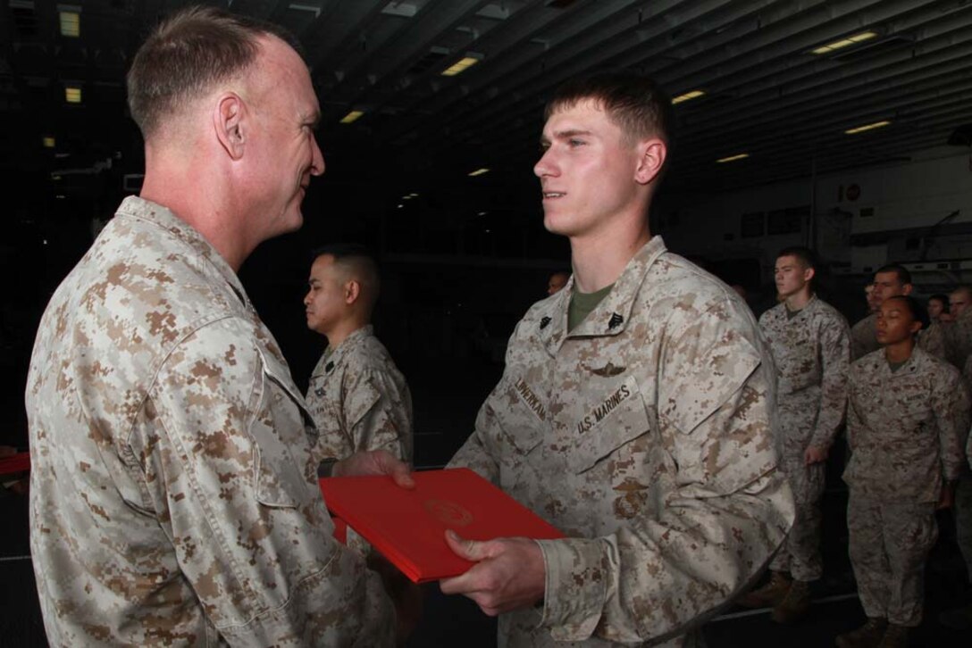 Newly promoted Sgt. Marvin T. Loverkamp, parachute rigger, Command Element, 15th Marine Expeditionary Unit, receives his promotion warrant from Col. Scott D. Campbell, his commanding officer, after being promoted during a ceremony held in the hangar bay of the USS Peleliu, Feb. 1. The 15th MEU is deployed as part of the Peleliu Amphibious Ready Group as a U.S. Central Command theater reserve force, providing support for maritime security operations and theater security cooperation efforts in the U.S. 5th Fleet area of responsibility. Loverkamp, 24, is from Brookport, Ill. (U.S. Marine Corps photo by Cpl. John Robbart III)