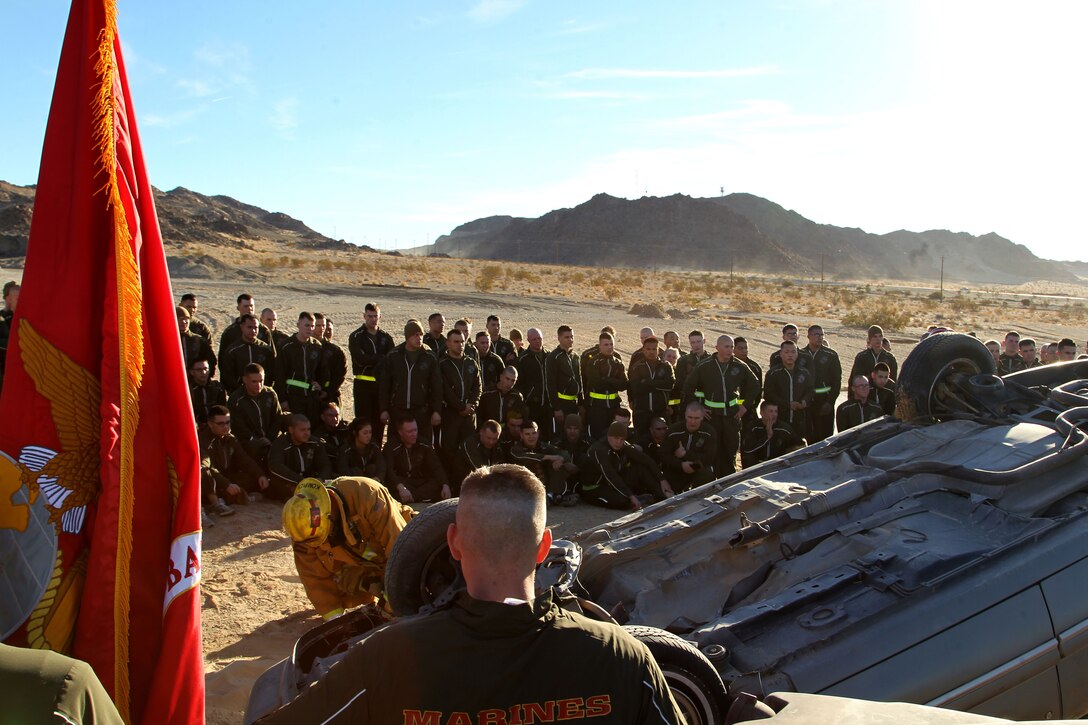 Marines surround the site of a simulated crash, set up by the unit as a way to teach the Marines about the importance of safe driving.