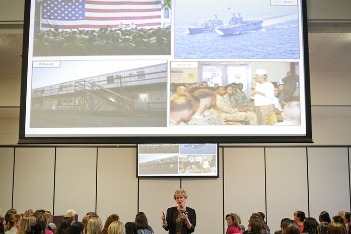 MARINE CORPS BASE CAMP PENDLETON, Calif. – Bonnie Amos, wife of Commandant of the Marine Corps Gen. James F. Amos, shows a slideshow of photos as she talks about her recent trip to visit Marines overseas during a military spouses’ conference here Jan. 31, 2013. Mrs. Amos spent the holidays in December 2012 traveling to different posts throughout Afghanistan in an effort to experience deployment life with Marines and convey it in her own words to military spouses on the home front. She said she believes the reason Marines have such high esprit de corps is due to the love and support they receive from their families back home. Mrs. Amos traveled with Gen. Amos, and Sergeant Major of the Marine Corps Micheal P. Barrett. 