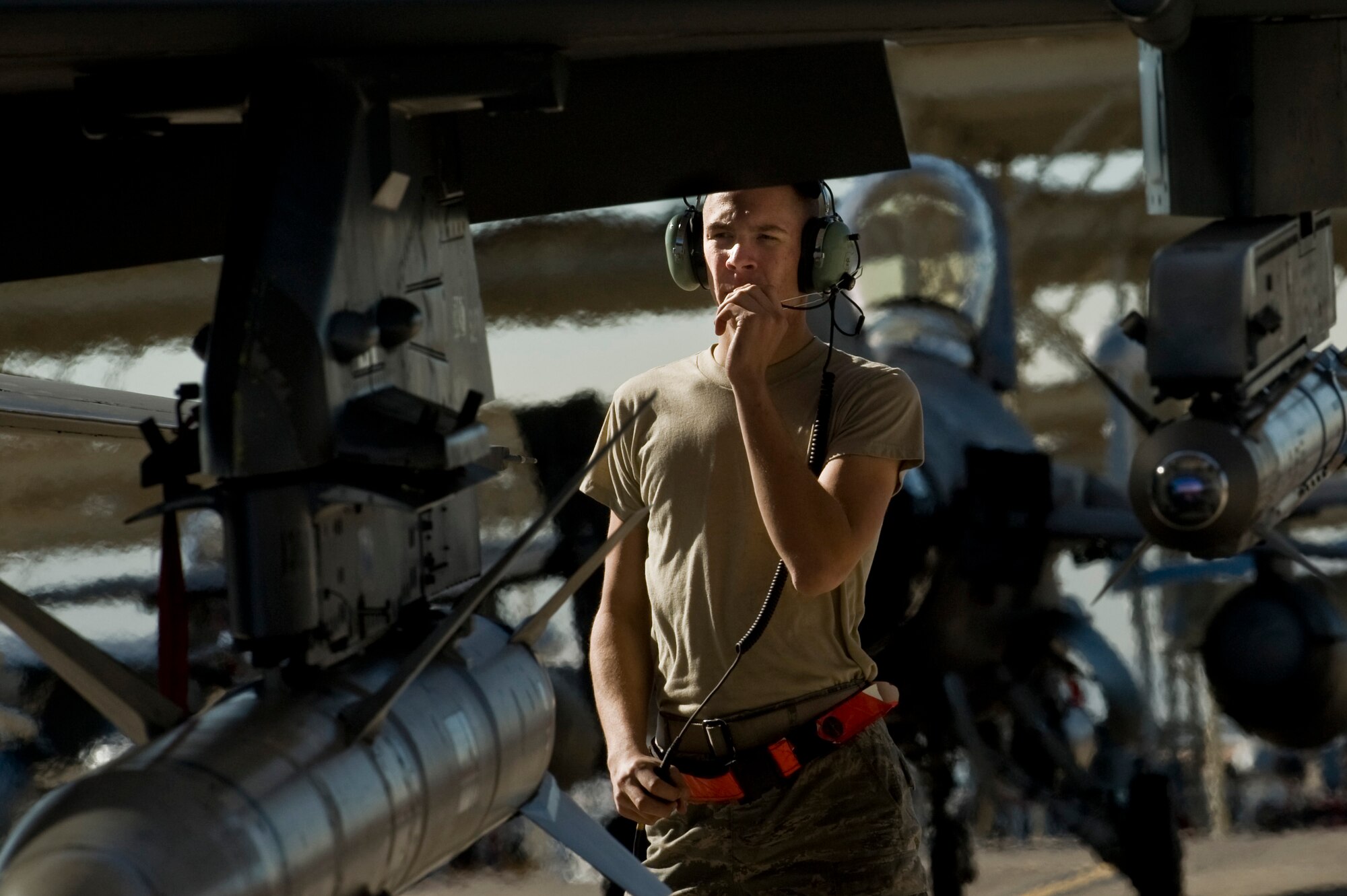 Airman 1st Class Daniel Lasal talks to the pilot before he marshals out an F-16 Fighting Falcon during Exercise Red Flag 13-2 Jan. 22, 2013, at Nellis Air Force Base, Nev. The crew chief is responsible for keeping the jets maintenance up to date and ensuring it is ready for every mission. Lasal is a crew chief assigned to the 480th Aircraft Maintenance Unit at Spangdahlem, Air Force Base, Germany, (U.S. Air Force photo/Senior Airman Daniel Hughes)