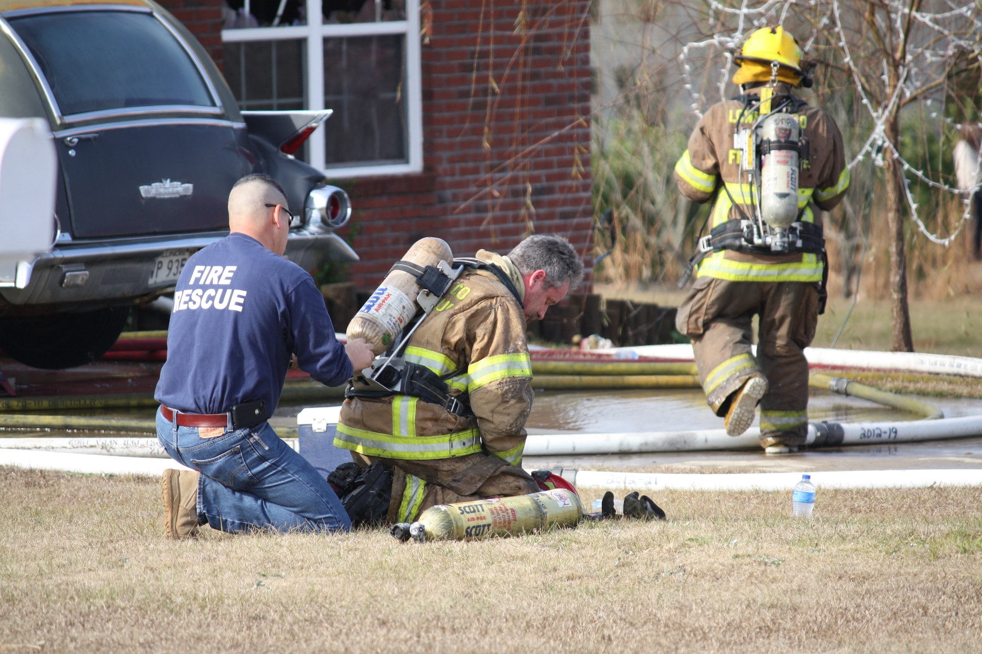 U.S. Air Force Master Sgt. Roderick Vega, 23d Wing deputy inspector general, changes out an air cylinder on a firefighter in Valdosta, Ga., Dec. 28, 2012. After the fire died down, Vega helped other firefighters by handing out water and changing air cylinders. (Courtesy Photo)