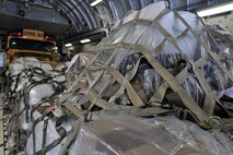 A school bus and pallets of corn, to be delivered to Guatemala, are loaded in a C-17, here, February 2. The supplies are being donated to people in need as part of a humanitarian program called Mission of Love. U.S. Air Force photo by Tech. Sgt. Valerie Smock