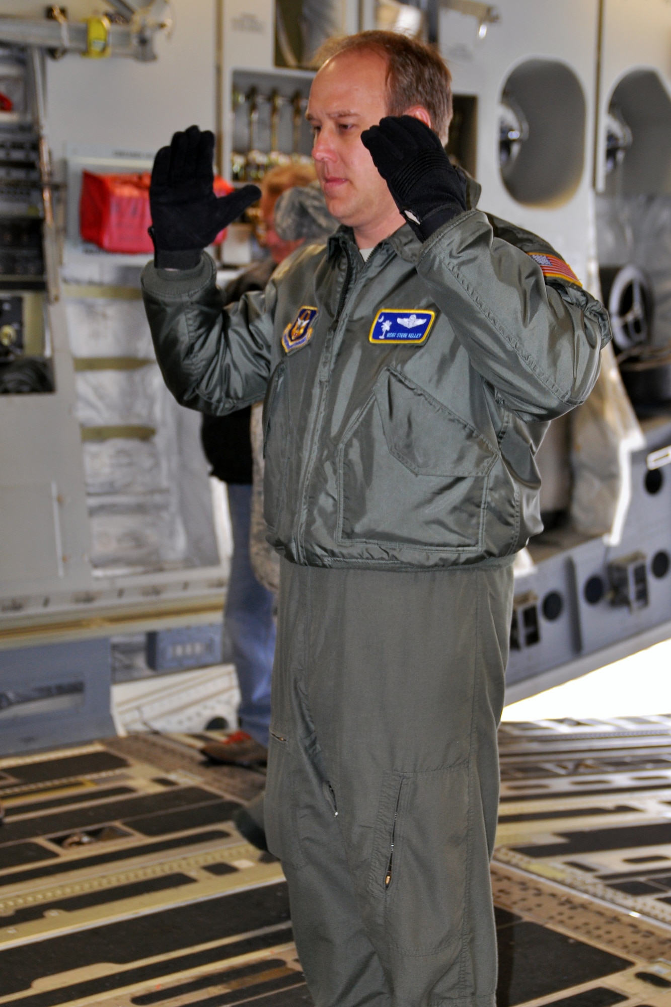 Air Force Reserve Master Sgt. Steve Kelley, a loadmaster assigned to 437th Operations Group, Charleston Air Base, South Carolina, helps direct a driver to put a school bus in place, here, February 2. The bus and pallets of corn are going to Guatemala as part of Mission of Love. U.S. Air Force photo by Tech. Sgt. Valerie Smock