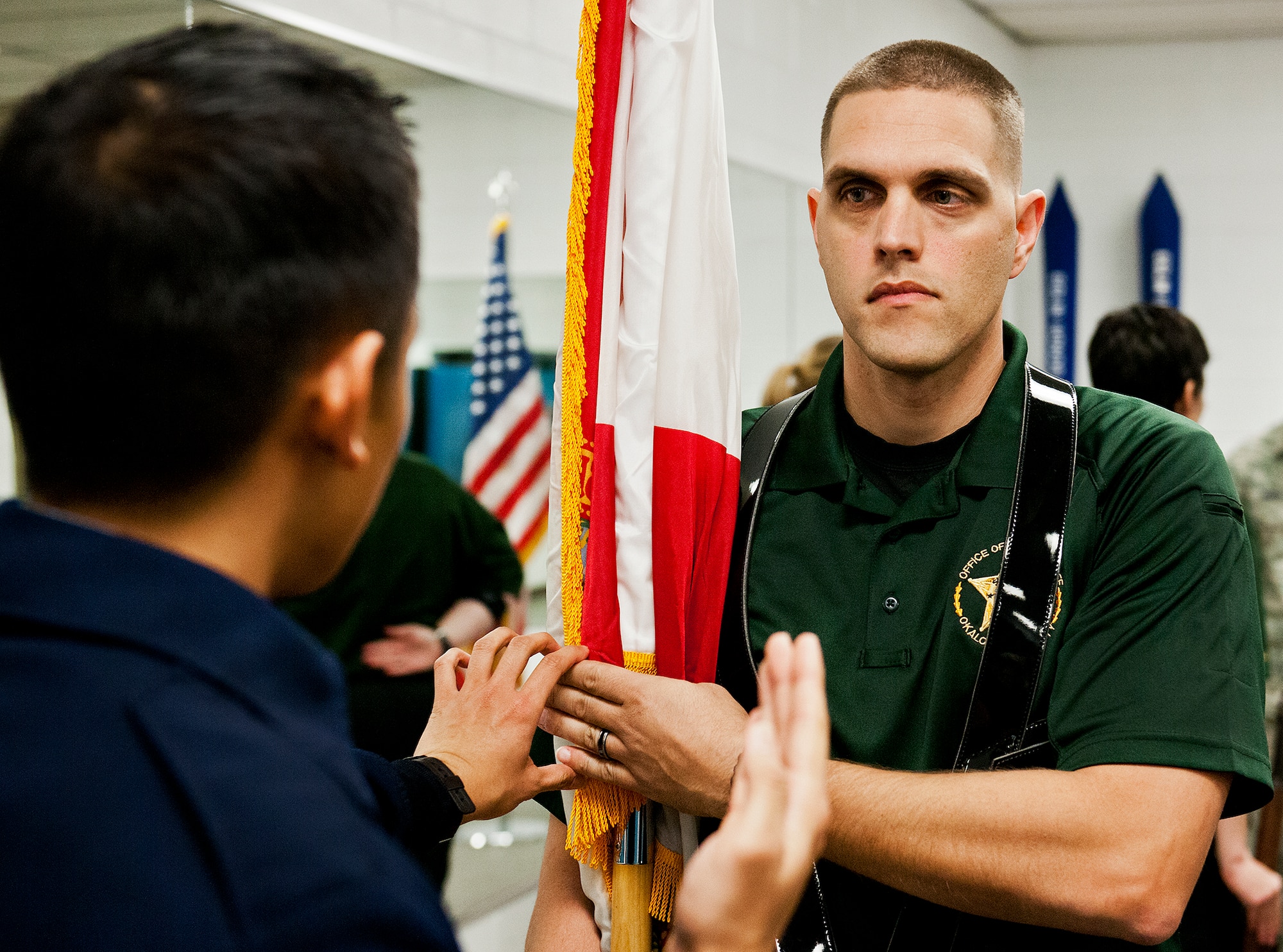 A member of Team Eglin’s Honor Guard shows Deputy Brad Suhi-Moore, of the Okaloosa County Sheriff’s Office Honor Guard, the proper way to hold a flag while carrying it at a ceremony during a training session on base Feb. 1.  The OCSO team came together with Eglin’s honor guard to learn military protocols used during various ceremonies such as retirements, funerals, etc.  During this first training session Eglin’s Airmen taught them proper movements while carrying flags and rifles.  This was the first of many proposed training sessions between the two teams.  (U.S. Air Force photo/Samuel King Jr.)