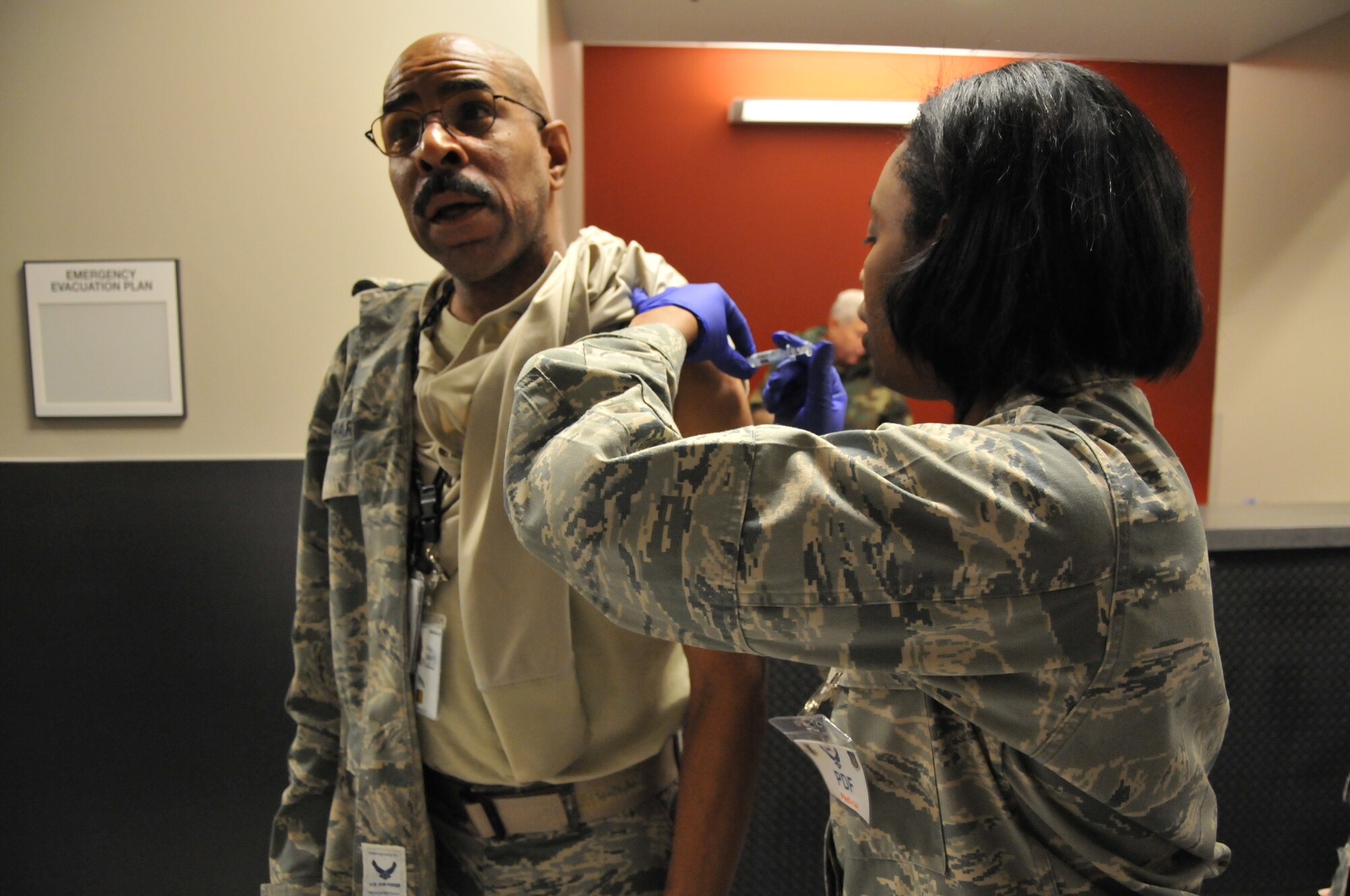 Master Sgt. Terry Harper, 94th Force Support Squadron chief of wing retention, recieves a flu shot on the deployment line during phase one of preparation for an upcoming operational readiness exercise on Jan. 6 here. This phase, the first of three, required participating Airmen to inventory and prepare equipment for shipment for a mock deployment and go through a deployment line in building 819 – recently renovated to accommodate an increased operational tempo. (U.S. Air Force photo/Senior Airman Elizabeth Van Patten)
