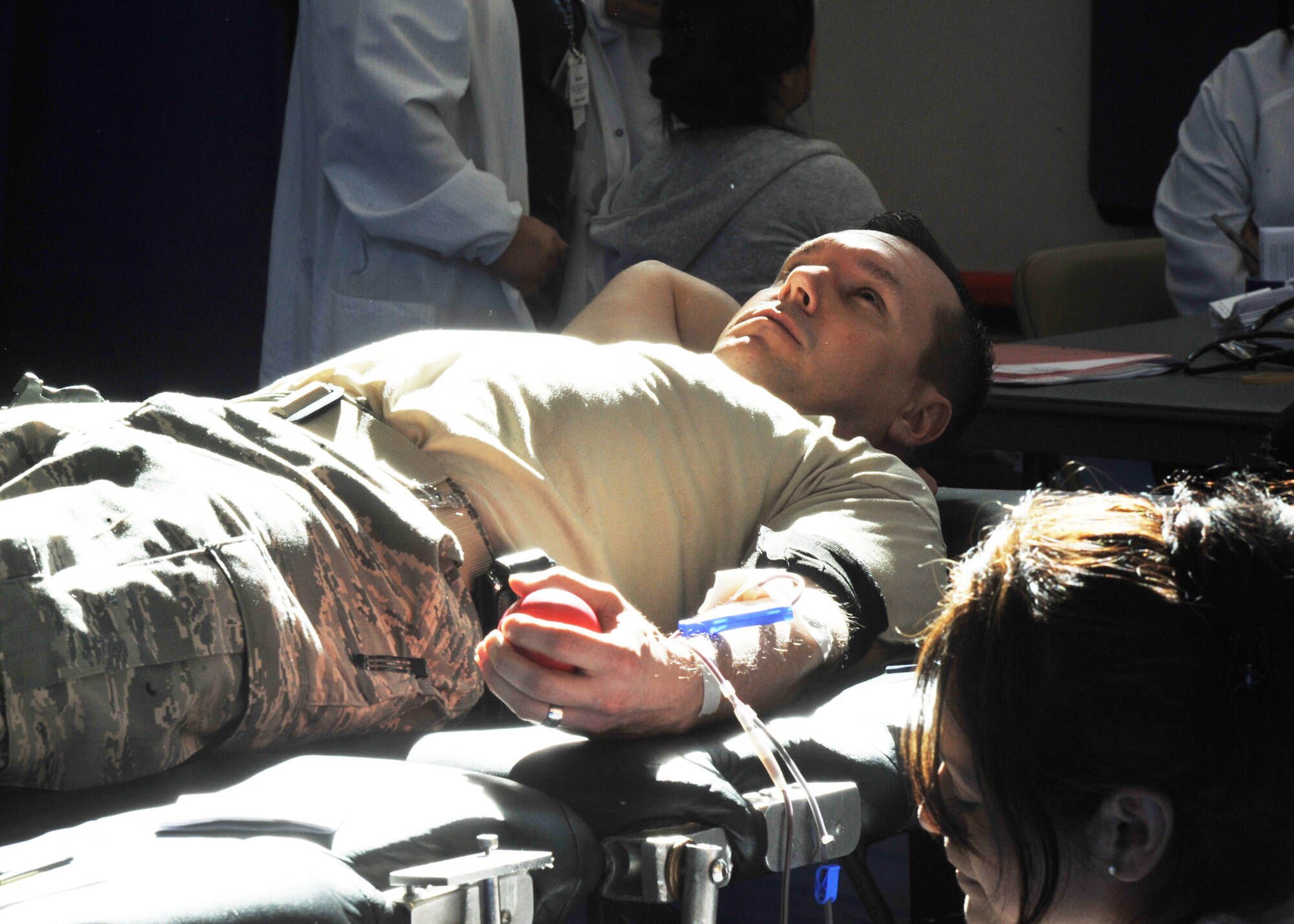 Senior Master Sergeant Justin Brodrick (left) donates blood while Red Cross technician Angie Castellanos (right) monitors his vitals at the Seventh Annual Battle of the Badges blood drive, Jan. 31.  The 61st Security Forces Squadron and other local police departments held blood drives and competed to see which department collected the most blood donations.  (Photo by Sarah Corrice)