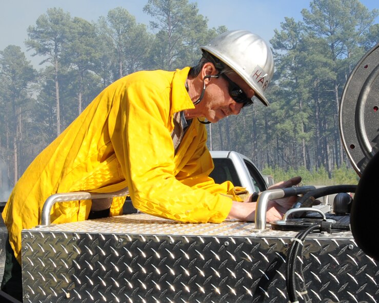 Keith Harris, 2nd Civil Engineer Squadron natural resources manager, fills up a water tank during a prescribed burn on Barksdale Air Force Base, La., Jan. 31. The water is used to help control and contain the fire if necessary. (U.S. Air Force photo/Senior Airman Sean Martin)
