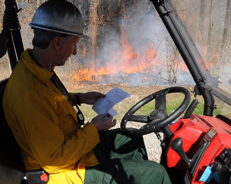 Keith Harris, 2nd Civil Engineer Squadron natural resources manager, looks at a map during a prescribed burn on the East Reservation. The 300-acre burn will allow for animals and trees to better flourish on the reservation by eliminating competition. (U.S. Air Force photo/Senior Airman Sean Martin)