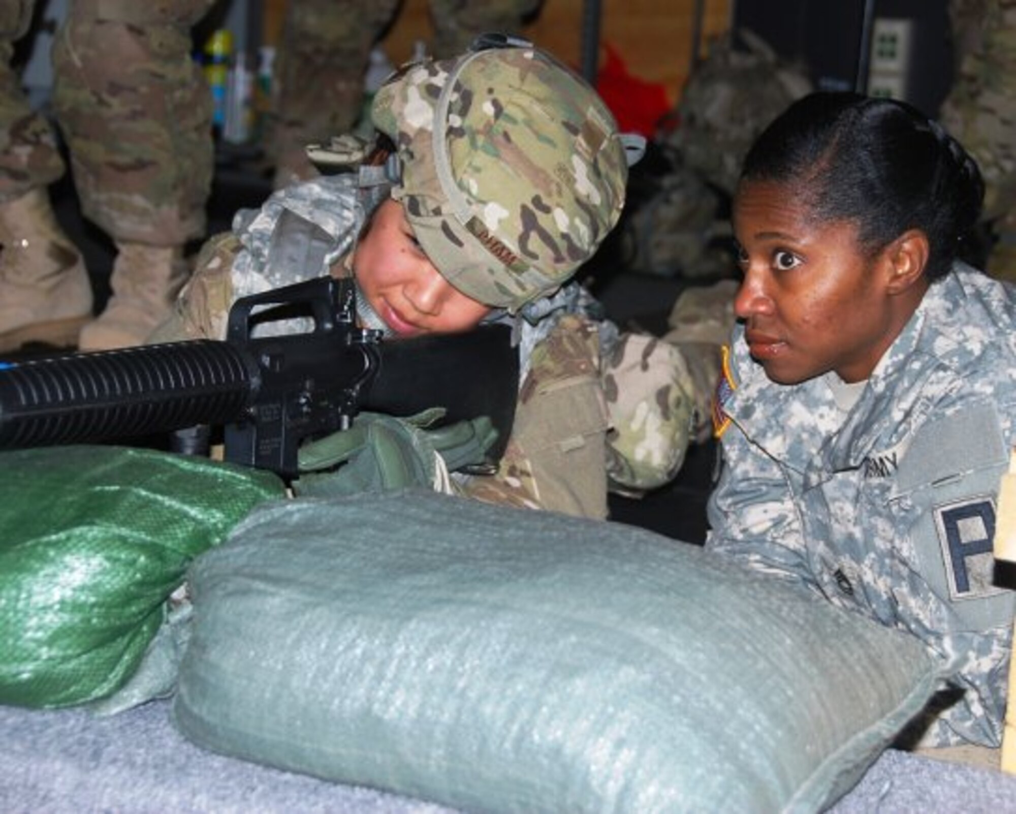 Sgt. 1st Class Katura Moorer, trainer/mentor with the 174th Infantry Brigade, First Army Division East, discusses shot placement and grouping with Staff Sgt. Stephanie Pham, from San Francisco, Calif., who is heading to Bagram Airfield, Afghanistan in February to assist an Explosive Ordinance Disposal team. (U.S. Army photo by Capt. Antonia Edwards/Released)