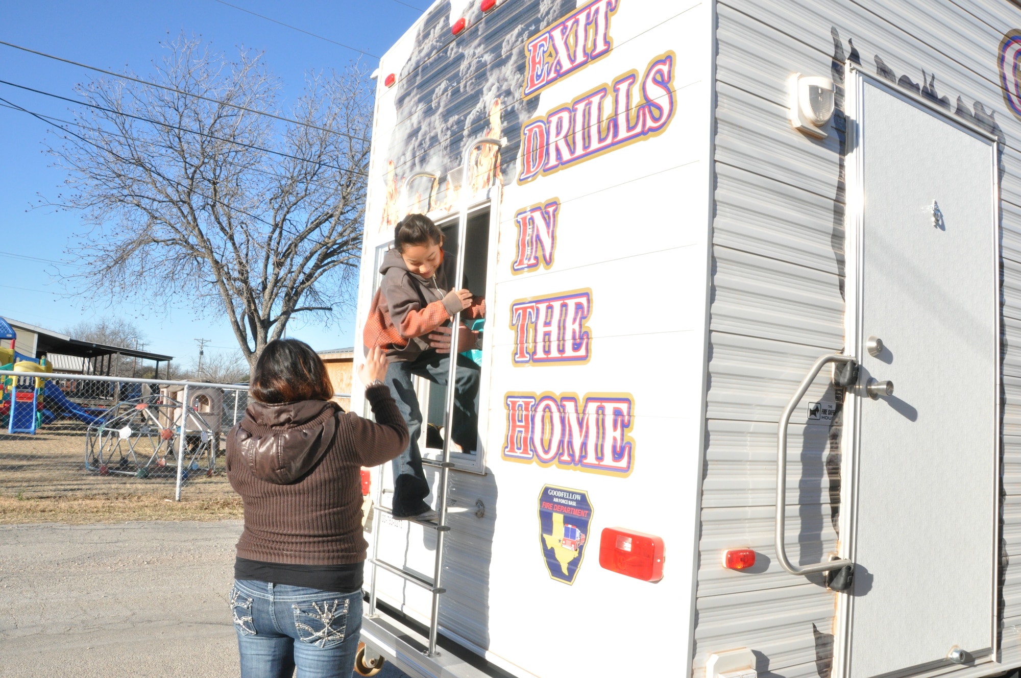 GOODFELLOW AIR FORCE BASE, Texas- An Eldorado Elementary School student climbs out the window of the 17th Civil Engineer Squadron’s mobile fire safety house in an emergency fire drill in Eldorado, Texas, Jan. 30. Members from the 17th CES brought the mobile fire safety house to teach the students ways to prevent fire in the home and what to do case of a fire.  (U.S. Air Force photo/ Airman 1st Class Erica Rodriguez)