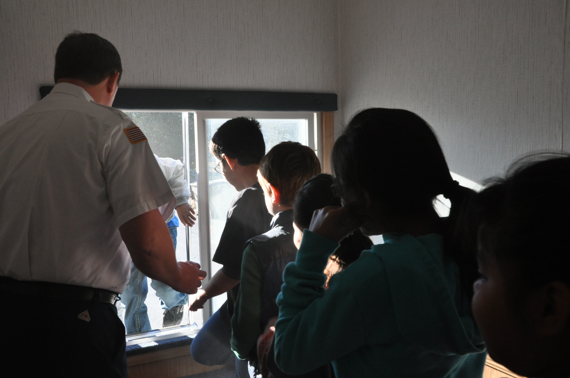 GOODFELLOW AIR FORCE BASE, Texas- Students from the Eldorado Elementary School climb out of a window from the mock bedroom in the 17th Civil Engineer Squadron’s mobile fire safety house in Eldorado, Texas, Jan.30. The students were going through an emergency fire drill in the mobile fire safety house which included simulated smoke and the sounding of a smoke detector. (U.S. Air Force photo/ Airman 1st Class Erica Rodriguez)