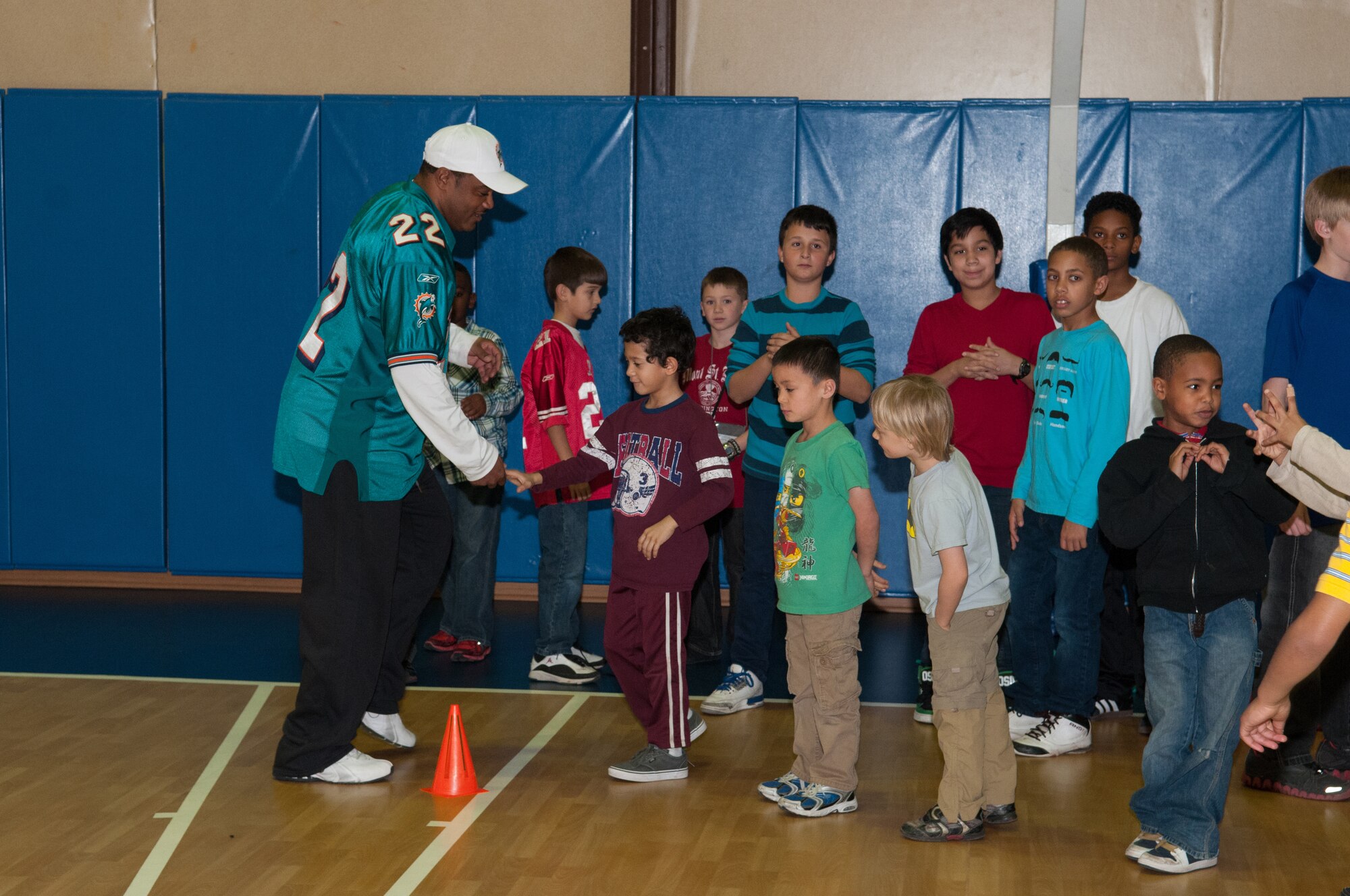 Incirlik children participate in a football clinic with Miami Dolphins alumni Troy Drayton and Shawn Wooden at the Youth Center, Jan. 30, 2013, at Incirlik Air Base, Turkey. The cheerleaders and football players made several morale appearances around the base including a radio show with the Incirlik American Forces Network, a cheer and football clinic with children and a performance at the Youth Center. (U.S. Air Force by Staff Sgt. Veuril McDavid/Released)