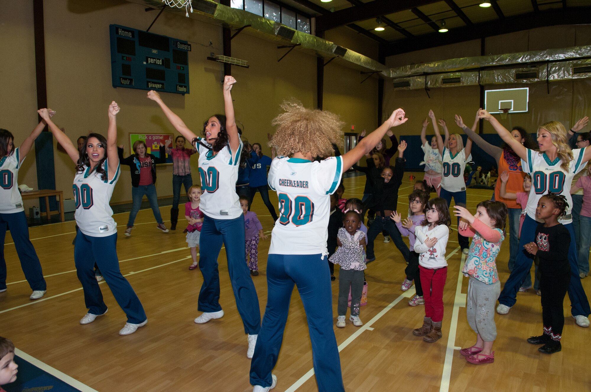 Incirlik children dance with Miami Dolphins Cheerleaders at the Youth Center, Jan. 30, 2013, at Incirlik Air Base, Turkey. The cheerleaders and football players made several appearances around the base including a radio show with the Incirlik American Forces Network, a cheer and football clinic with base children and a performance at the Youth Center. (U.S. Air Force by Staff Sgt. Veuril McDavid/Released)