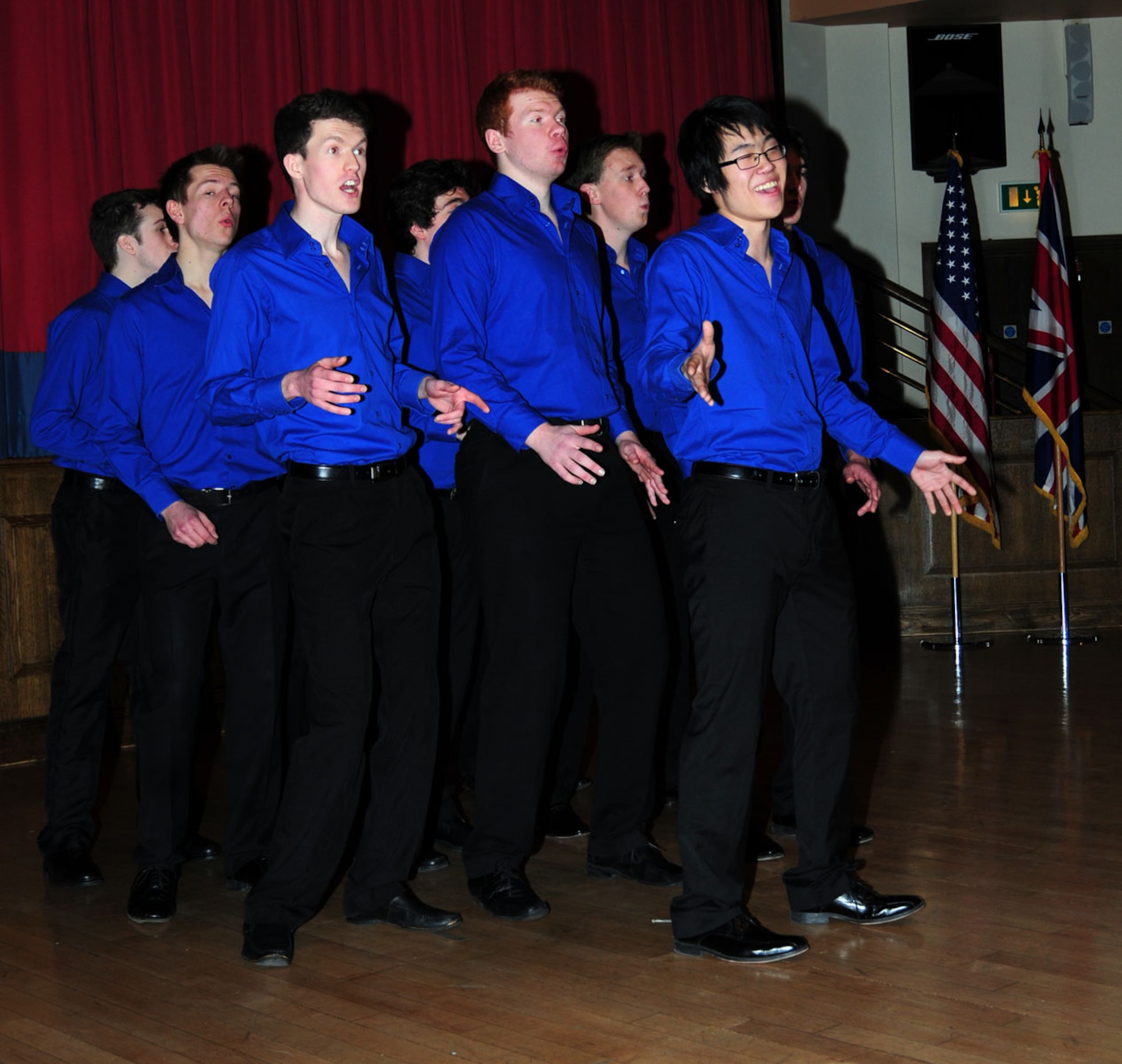 Eunsong Lee, right, leads collegiate acapella group, “All the King’s Men,” during their performance of the song “Africa” Feb. 3, 2013, at the Galaxy Club on RAF Mildenhall, England. The acapella group, here from King’s College, London, performed at RAF Mildenhall before heading to the United States to perform at universities there. (U.S. Air Force photo by Karen Abeyasekere/Released)