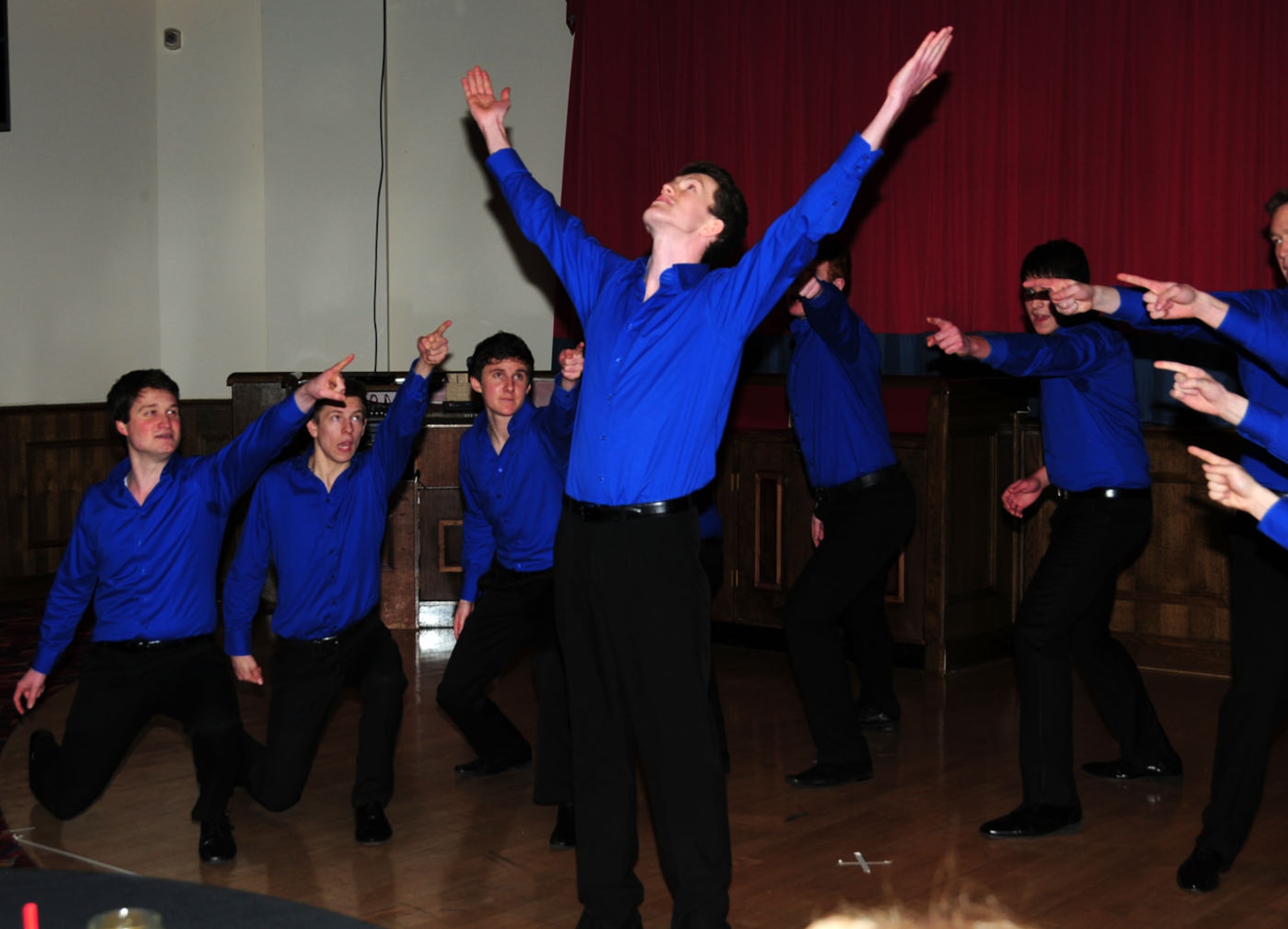 Josh Darley, center, leads acapella collegiate group, "All the King's Men," from King's College, London, during their version of "Livin' La Vida Loca" at their show Feb. 3, 2013, at the Galaxy Club, RAF Mildenhall, England. The group will soon travel to the United States to perform at universities there. (U.S. Air Force photo by Karen Abeyasekere/Released) 