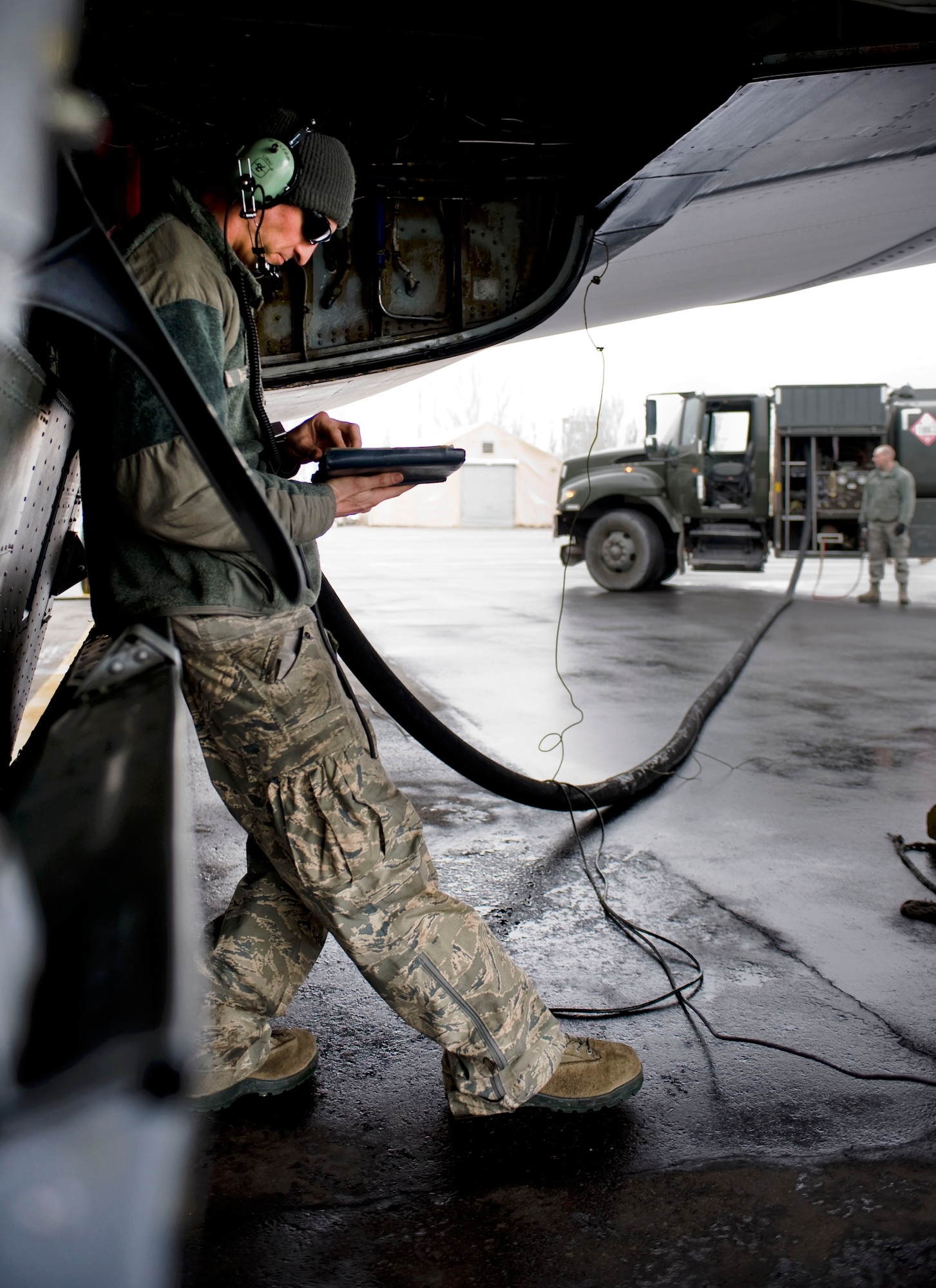 Staff Sgt. Alexander Lesch, 376th Expeditionary Aircraft Maintenance Squadron crew chief, checks a technical order during the refueling of a KC-135 Stratotanker Feb. 4, 2013, at Transit Center at Manas, Kyrgyzstan. Lesch is deployed from McConnell Air Force Base, Kan., and is a native of Burlington, Wis.  (U.S. Air Force photo/Staff Sgt. Stephanie Rubi)