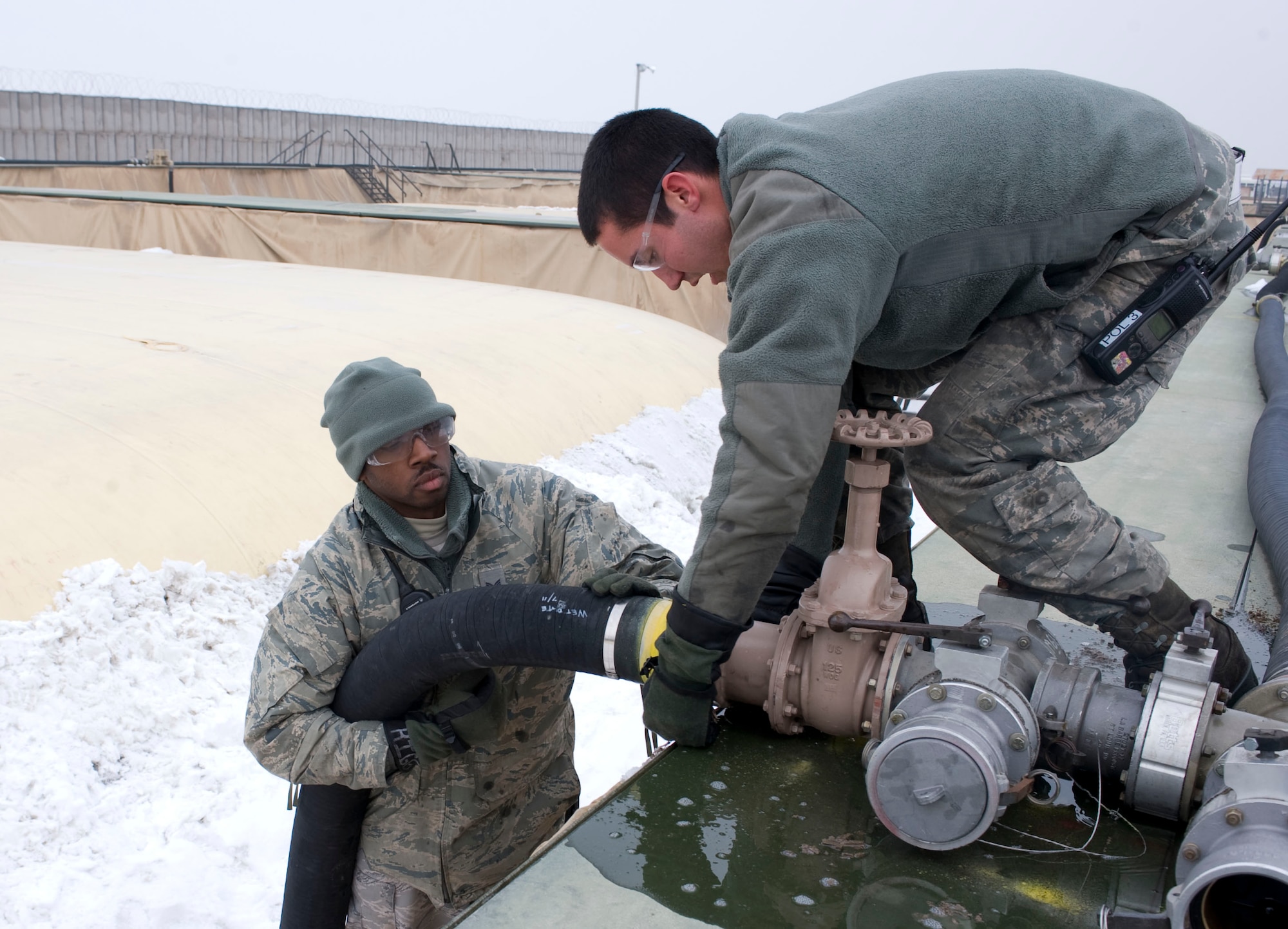 Left, Staff Sgt. Maurice Collins, 376th Expeditionary Logistics Readiness Squadron bulk storage supervisor, and Airman 1st Class David Branson, 376th ELRS bulk storage apprentice, attach a fuel line to a gate valve Jan. 31, 2013, at Transit Center at Manas, Kyrgyzstan. Bulk storage Airmen are expecting to install 48 new valves by the end of the month. Collins is deployed from Robins Air Force Base, Ga., and a native Baton Rouge, La. Branson is deployed from Charleston AFB, S.C., and is a native of Antioch, Calif. (U.S. Air Force photo/Staff Sgt. Stephanie Rubi)