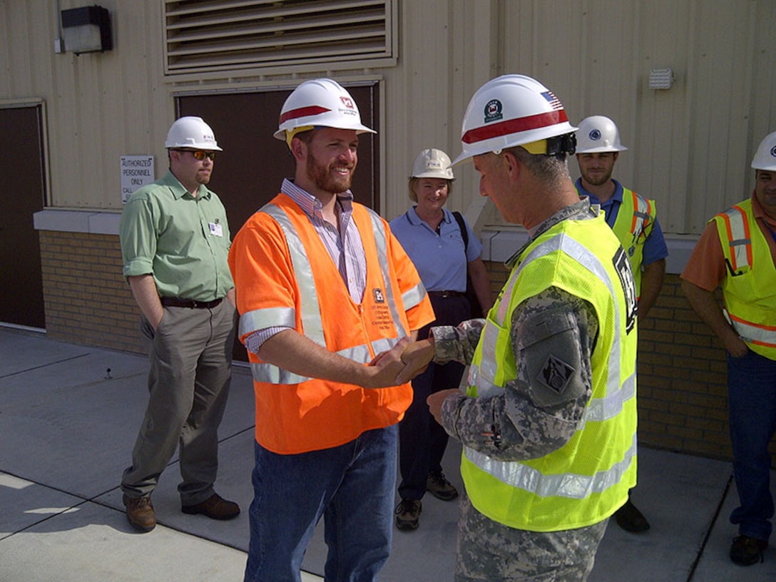 Matthew C. Polley, fire protection engineer, shakes hands with the Tulsa District Commander after a hangar high expansion foam dump test.