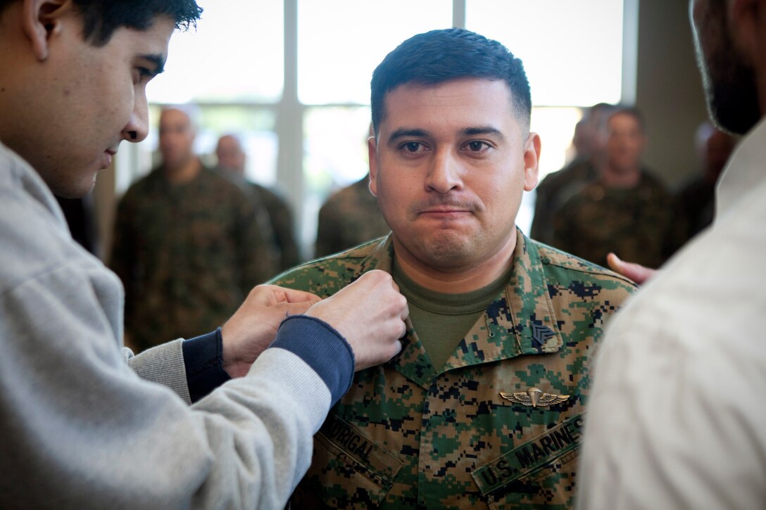 MARINE CORPS RECRUIT DEPOT, SAN DIEGO -- Sgt. Miguelange G. Madrigal, a radio chief with Supporting Arms Liaison Team G, 1st Air Naval Gunfire Liaison Company, I Marine Expeditionary Force Headquarters Group, is pinned on the rank of sergeant by his brother, Oscar Madrigal, and his prior team chief, former Sgt. Michael Dickinson, before being awarded the Silver Star Medal aboard Marine Corps Recruit Depot, San Diego, Jan. 31, 2013. Madrigal is out of the Marine Corps now but he never pinned on sergeant before the end of his service. Dickinson was part of the five-man team when Madrigal demonstrated the extraordinary valor that earned him the Silver Star Medal. (U.S. Marine Corps photo by Cpl. Marcin Platek/Released)