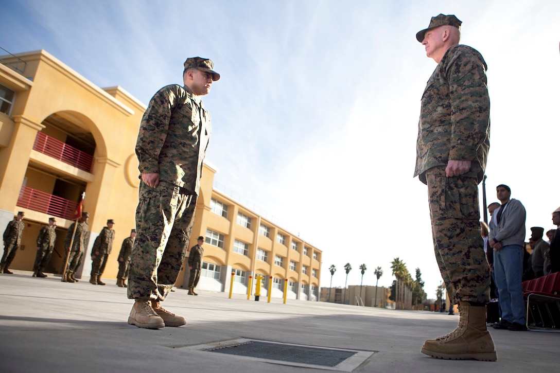 MARINE CORPS RECRUIT DEPOT, SAN DIEGO-- Sgt. Miguelange G. Madrigal, a radio chief with Supporting Arms Liaison Team G, 1st Air Naval Gunfire Liaison Company, I Marine Expeditionary Force Headquarters Group, reports to Lt. Gen. Steven A. Hummer, commander of Marine Forces Reserve and Marine Forces North, before being awarded a Silver Star Medal aboard Marine Corps Recruit Depot, San Diego, Jan.  31, 2013. The ceremony took place in front of a building named after Madrigal’s senior drill instructor, Staff Sgt. Allan K. Walker, who was killed in action in Ramadi, Iraq in 2004. (U.S. Marine Corps photo by Cpl. Marcin Platek/Released), 